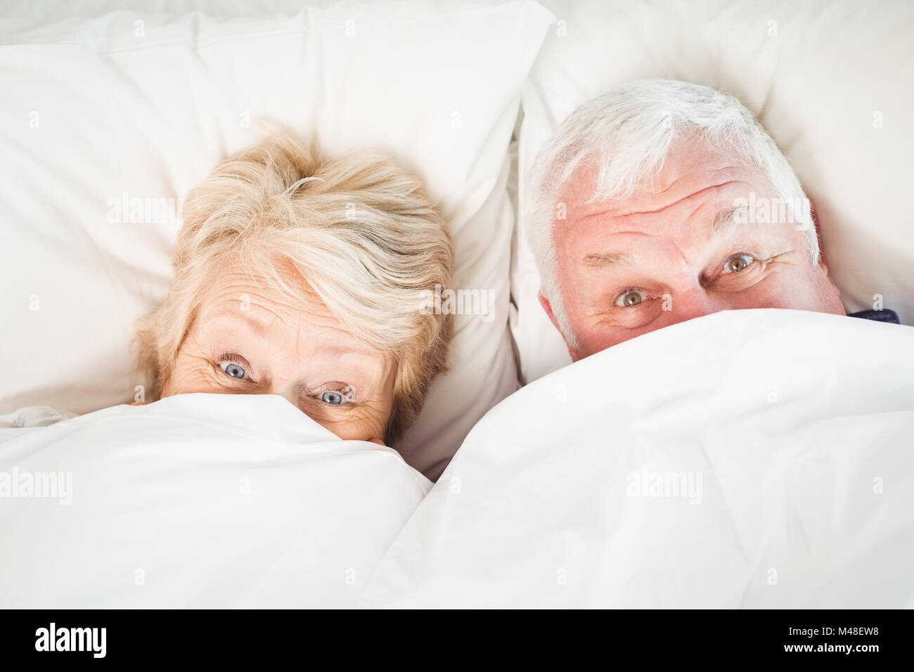 Overhead portrait of couple hiding in blanket Stock Photo Alamy
