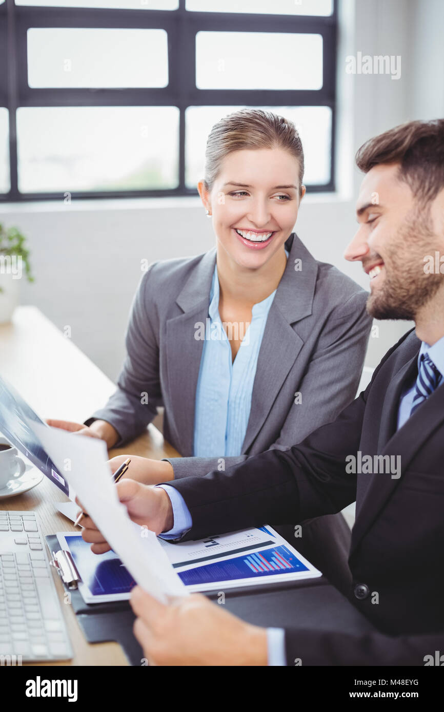 Smiling business people discussing over documents Stock Photo - Alamy