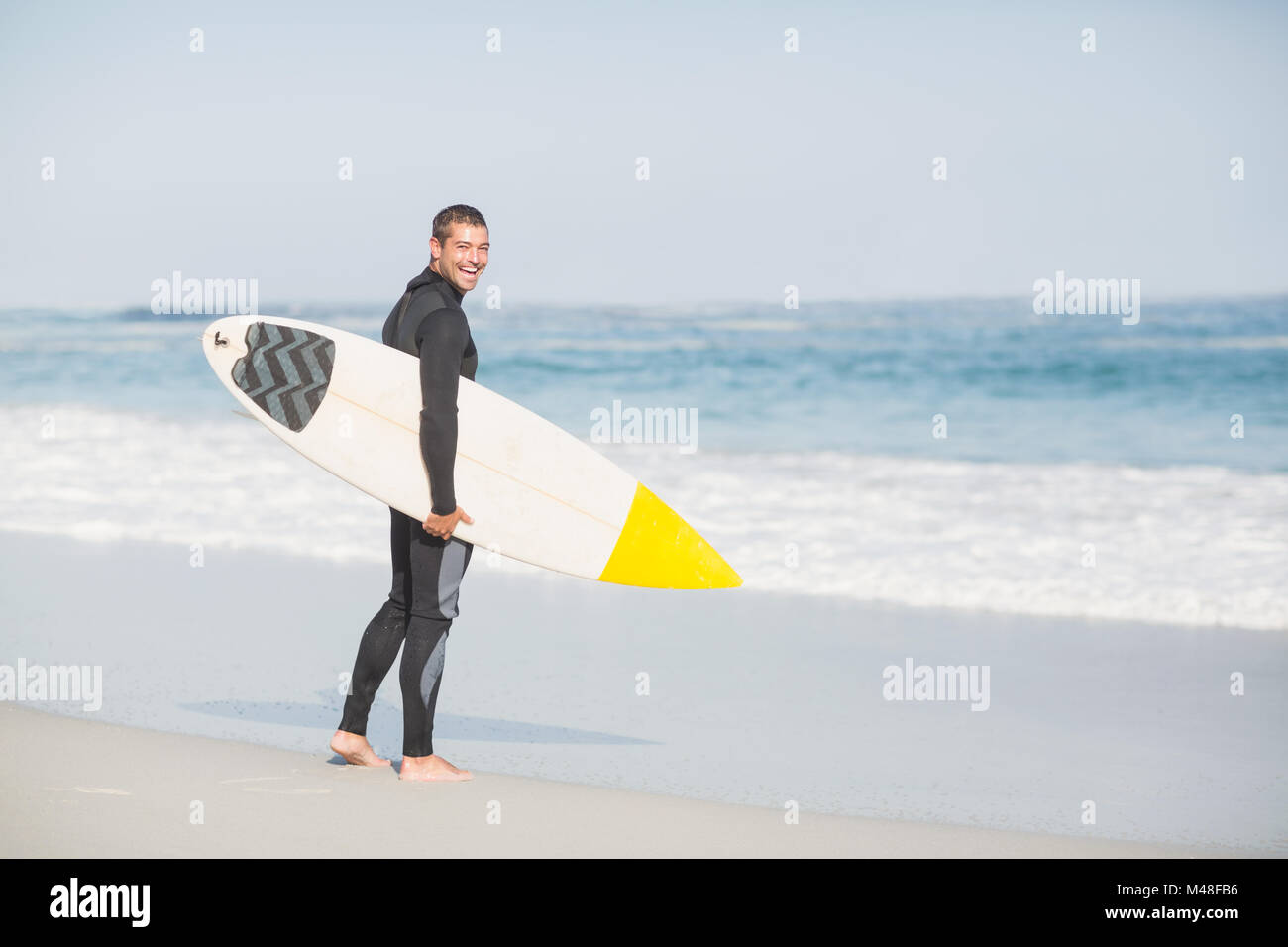 Surfer walking on the beach with a surfboard Stock Photo - Alamy
