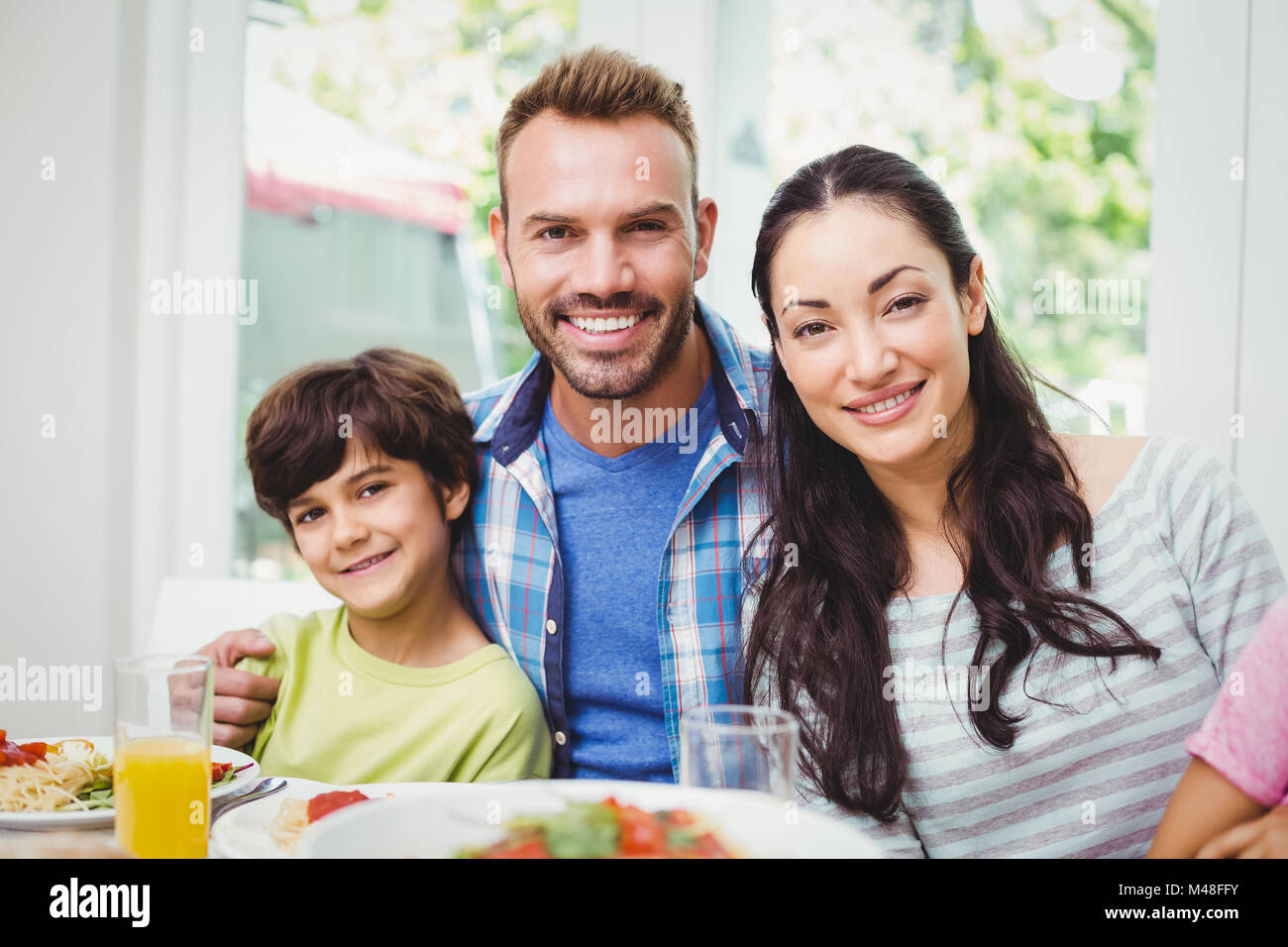 Portrait of smiling parents and son at dining table Stock Photo - Alamy