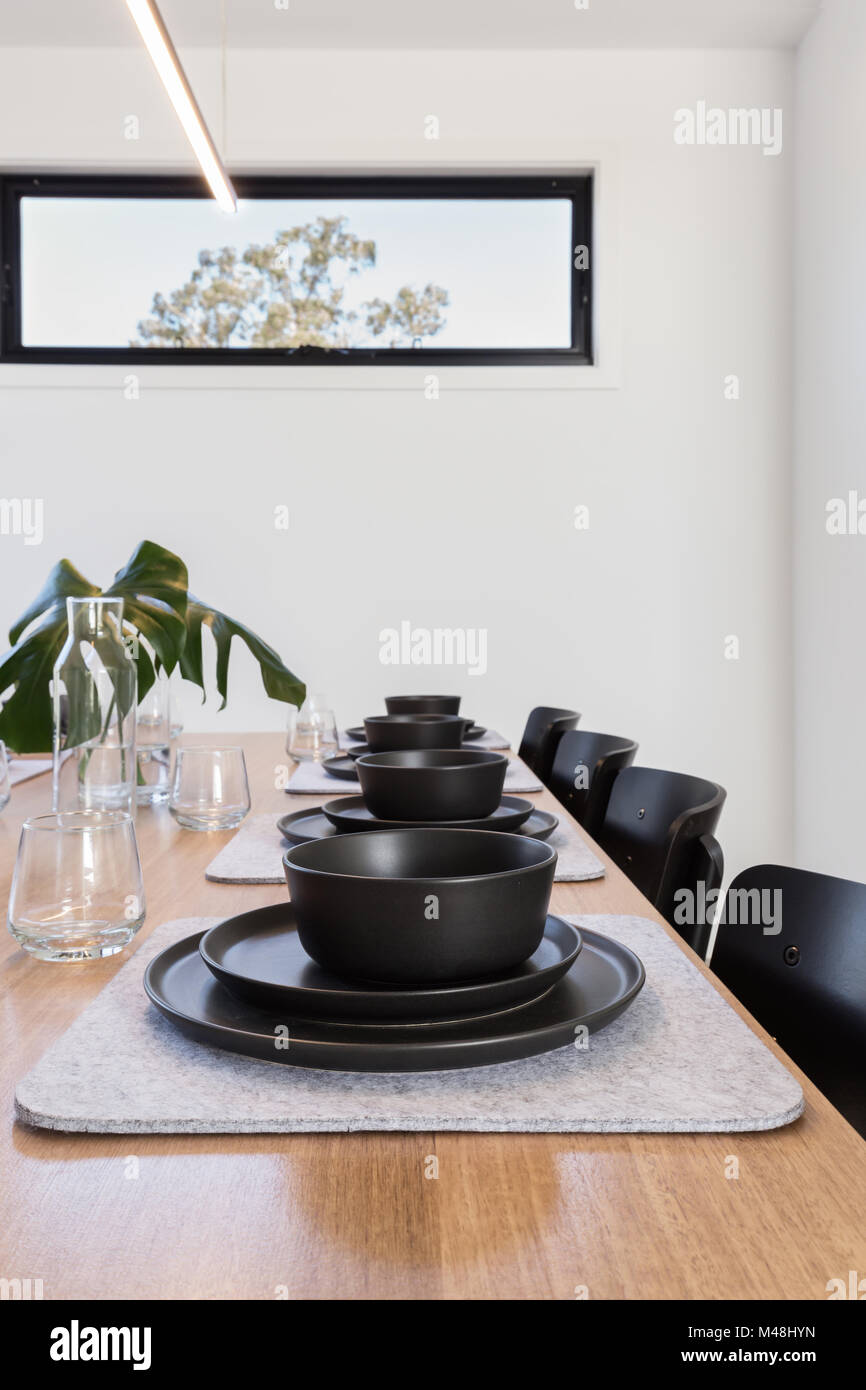 Table setting details of charcoal crockery and felt grey place mats Stock Photo