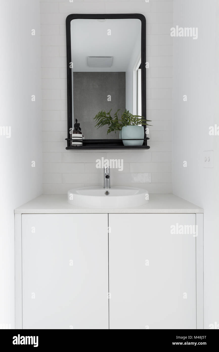 Monochrome powder room vanity black mirror and white tiling Stock Photo