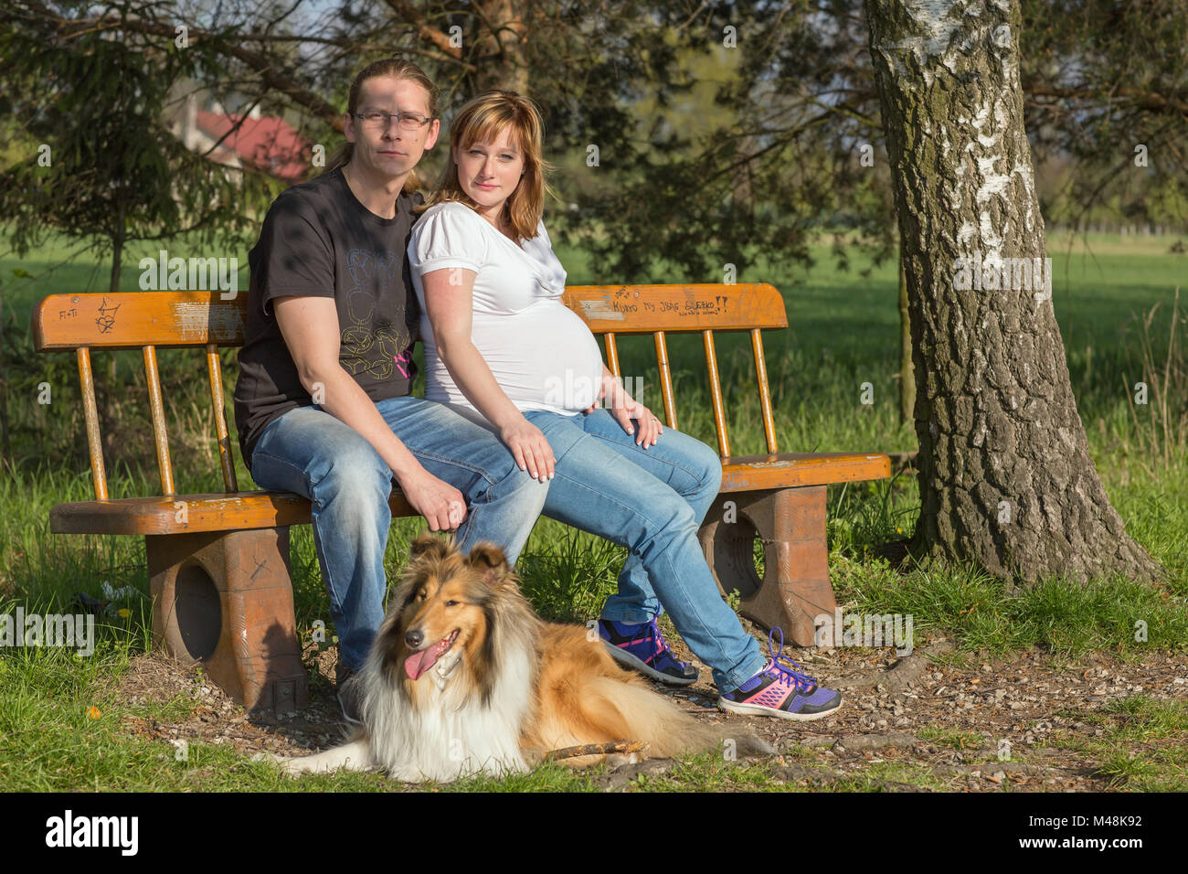 Happy family sitting on a bench in spring nature Stock Photo