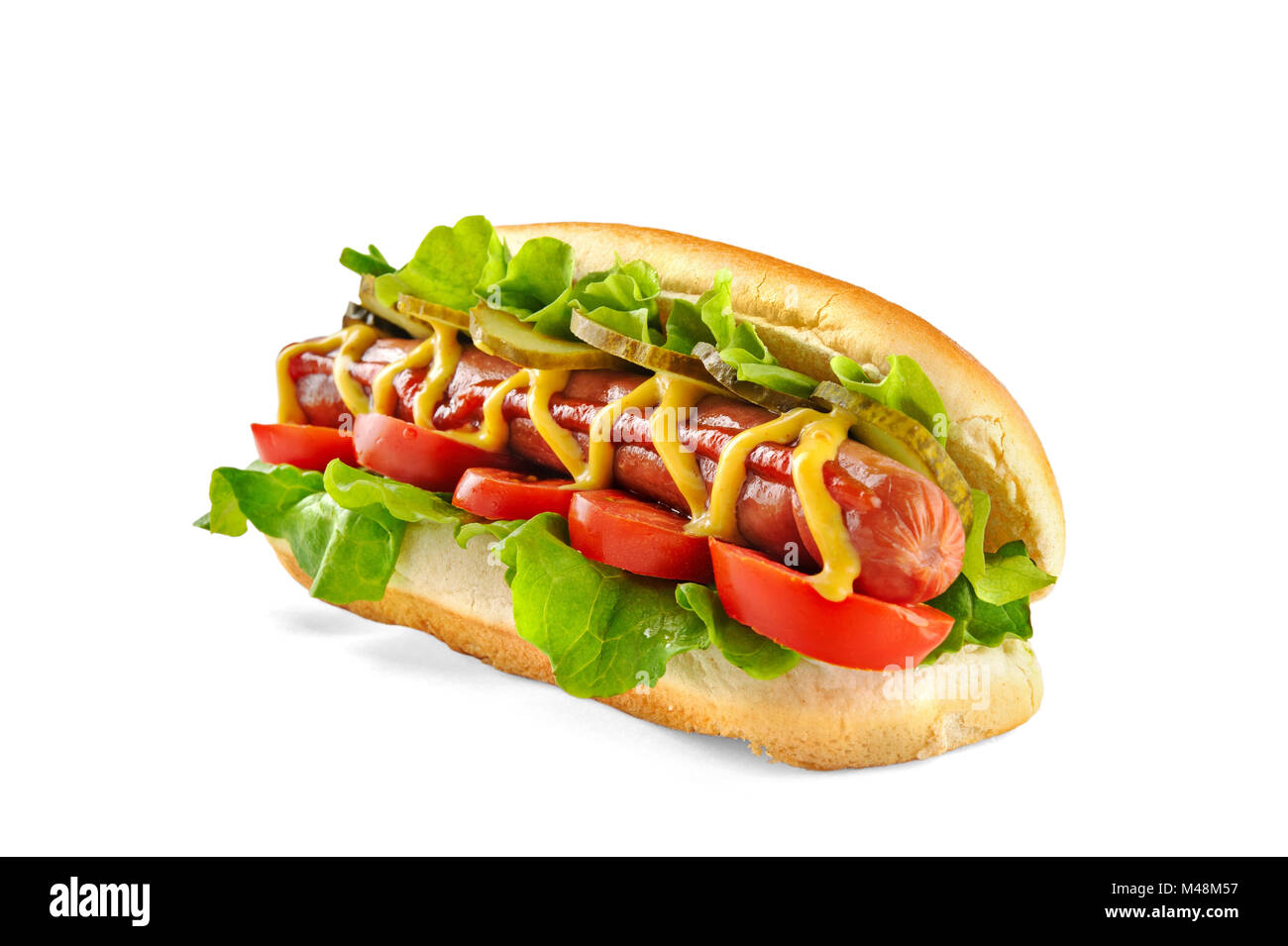 Hotdog with big sausage and fresh tomato, lettuce and mustard isolated