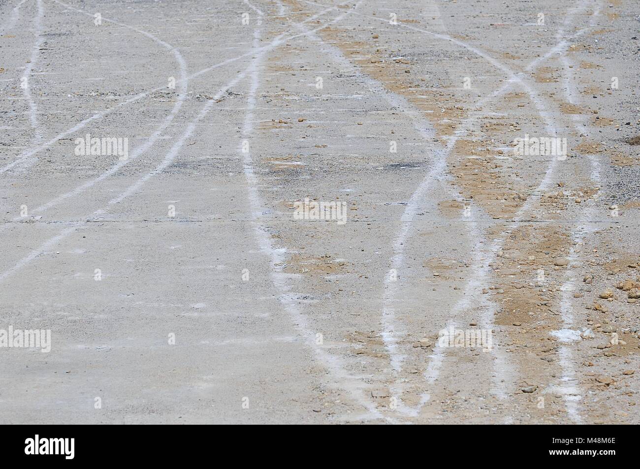 Traces of the construction site on the concrete pavement Stock Photo