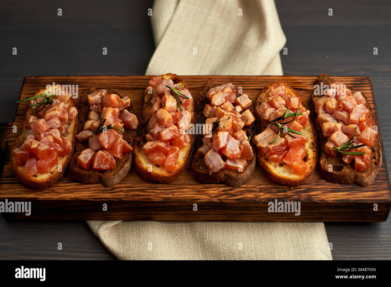 bruschetta with delicious fish on a cream cushion with capers and olive