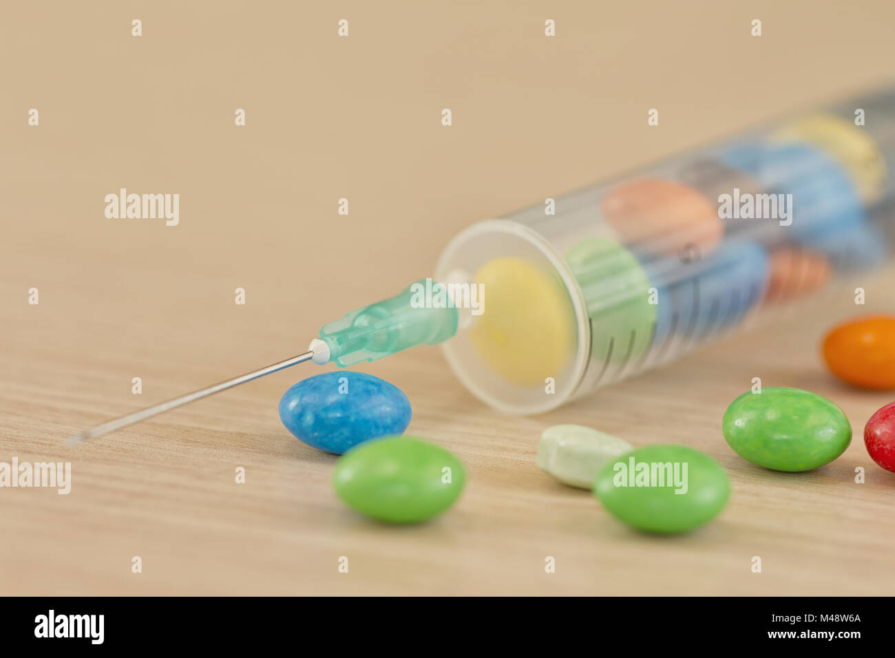 The syringe is charged by injection of sweets Stock Photo Alamy