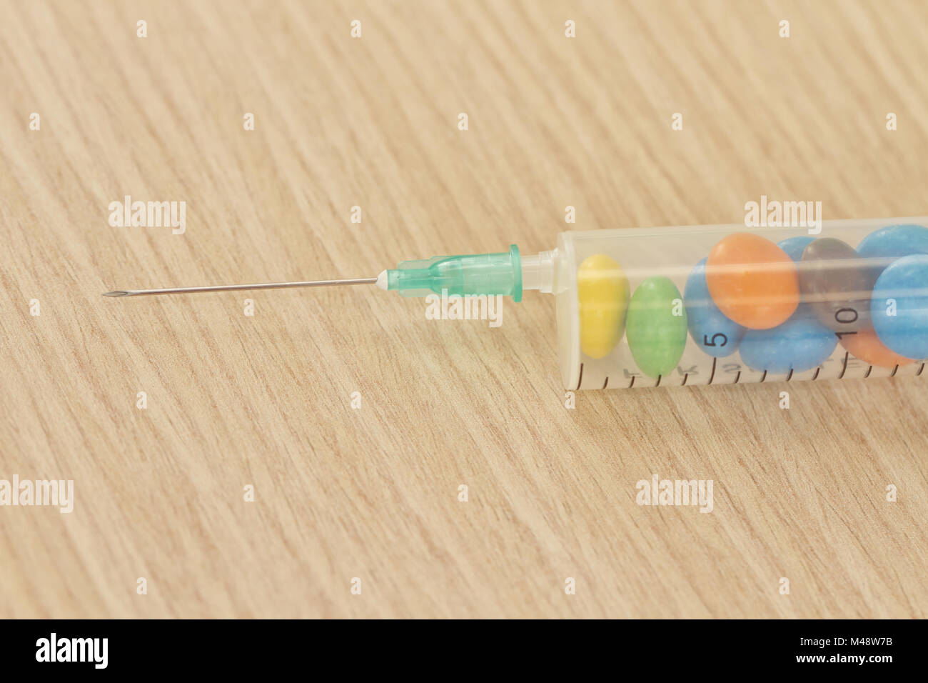 The syringe is charged by injection of sweets Stock Photo Alamy