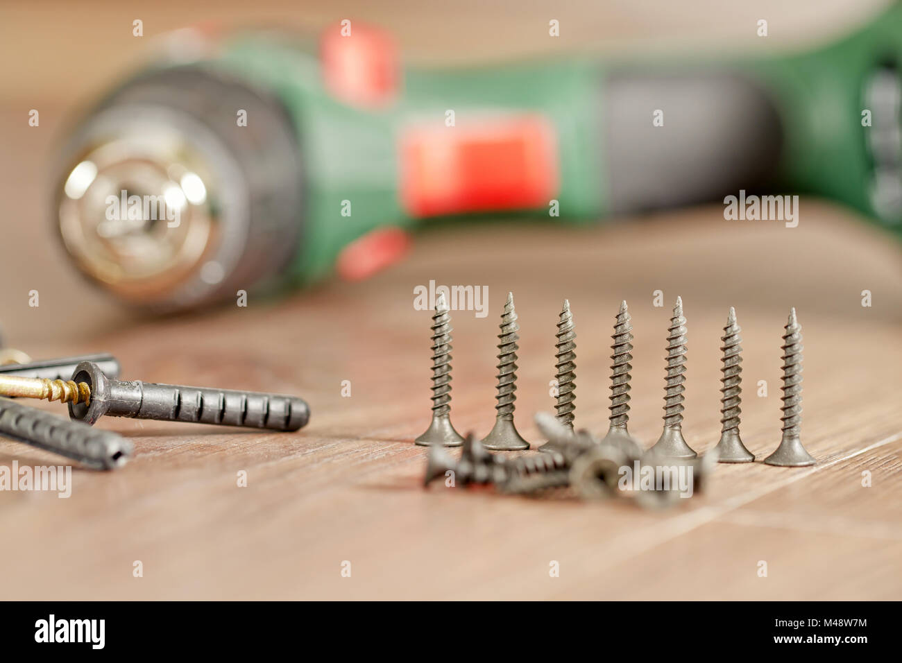 Screws and fasteners lie on the background of the screwdriver Stock Photo