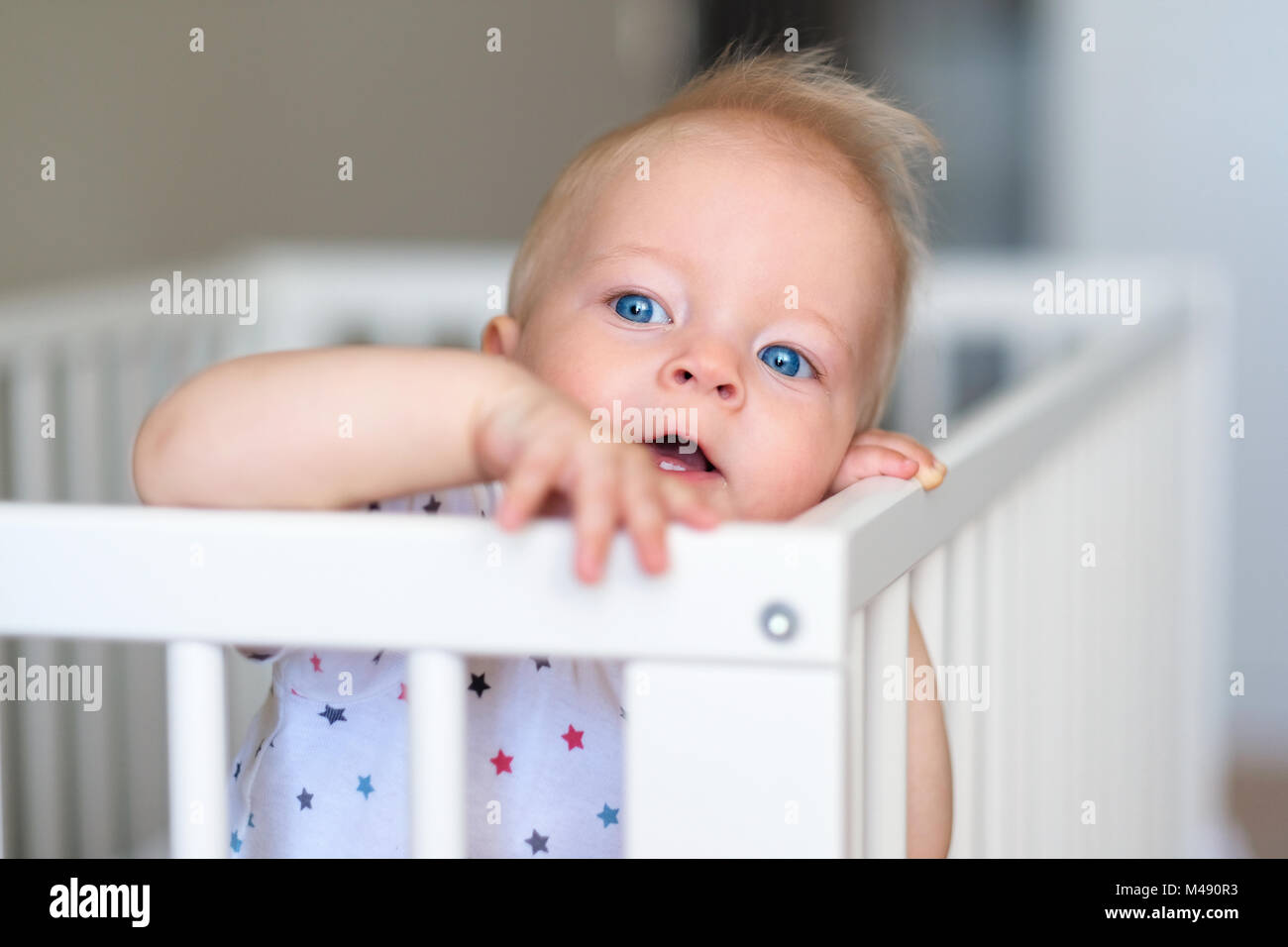 Baby boy standing in crib Stock Photo Alamy