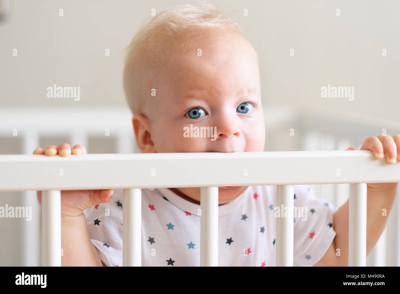 Baby boy standing in crib Stock Photo Alamy