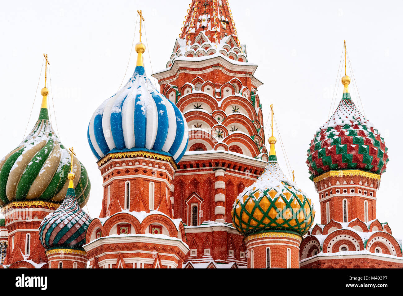 Beautiful, famous Moscow Saint Basil Cathedral walls and domes in wintertime. Red building colorful cupolas, white sky Stock Photo