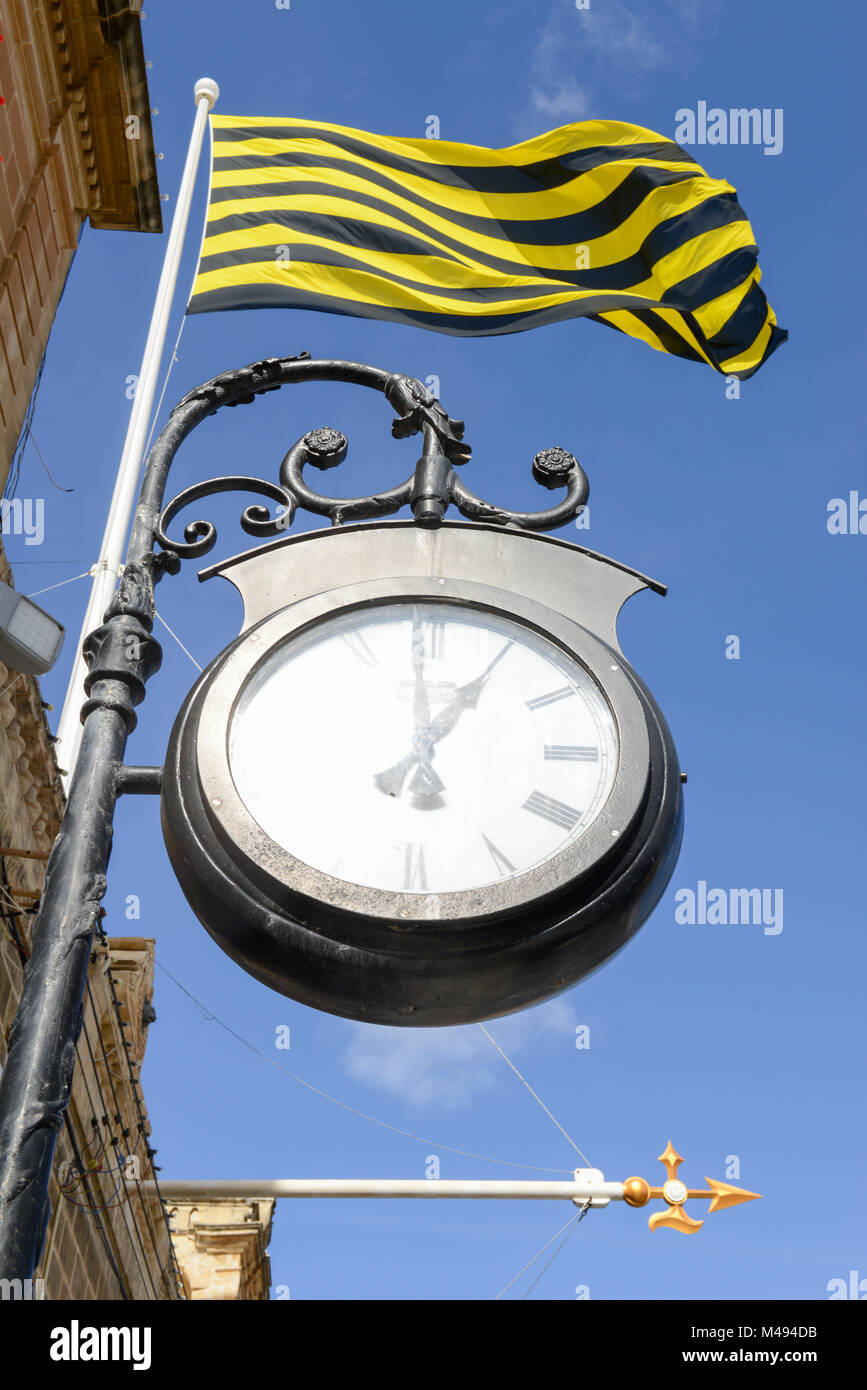Old city street clock on a house wall of Victoria in Gozo island, Malta