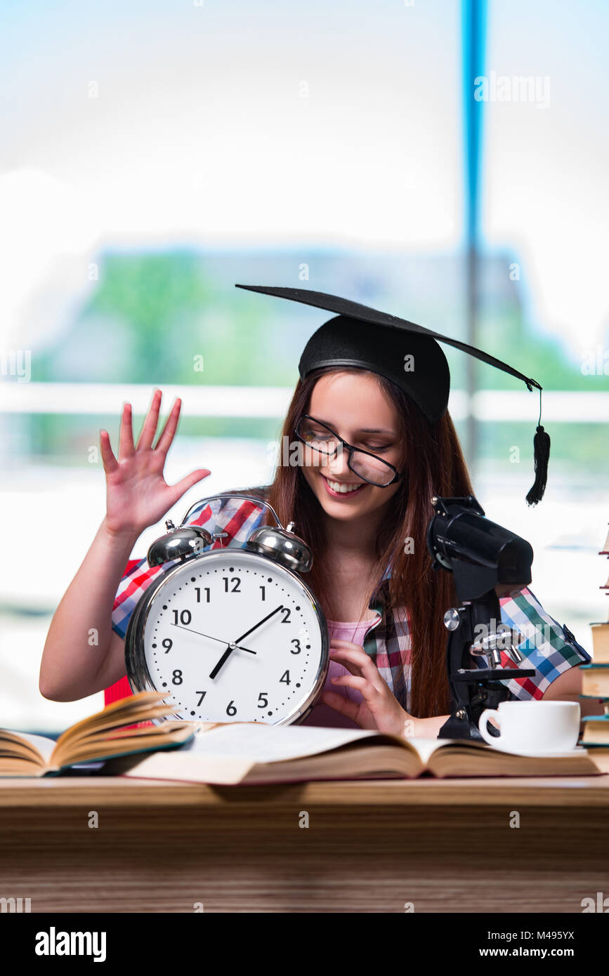 Young girl preparing for exams with large clock Stock Photo Alamy
