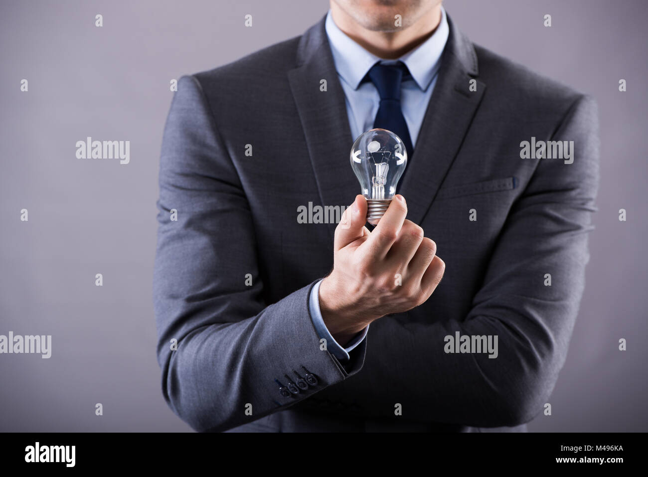 Businessman holding light bulb in creativity concept Stock Photo - Alamy
