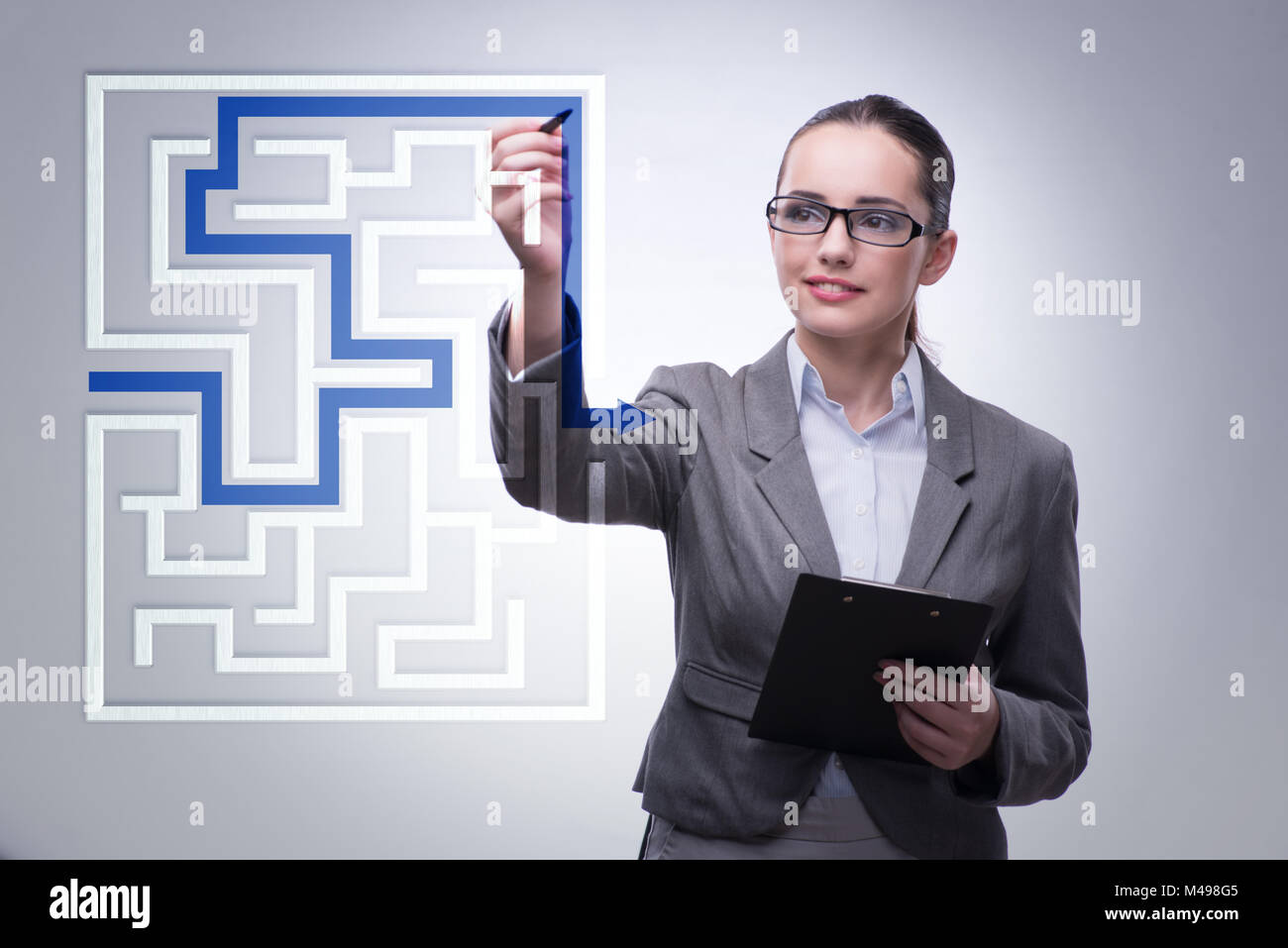 Businesswoman with maze in difficult situations concept Stock Photo - Alamy
