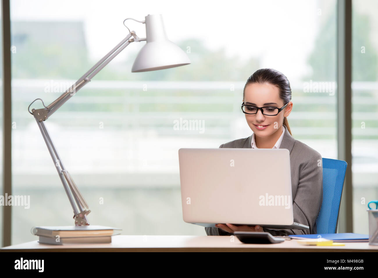 Businesswoman working at her desk Stock Photo - Alamy