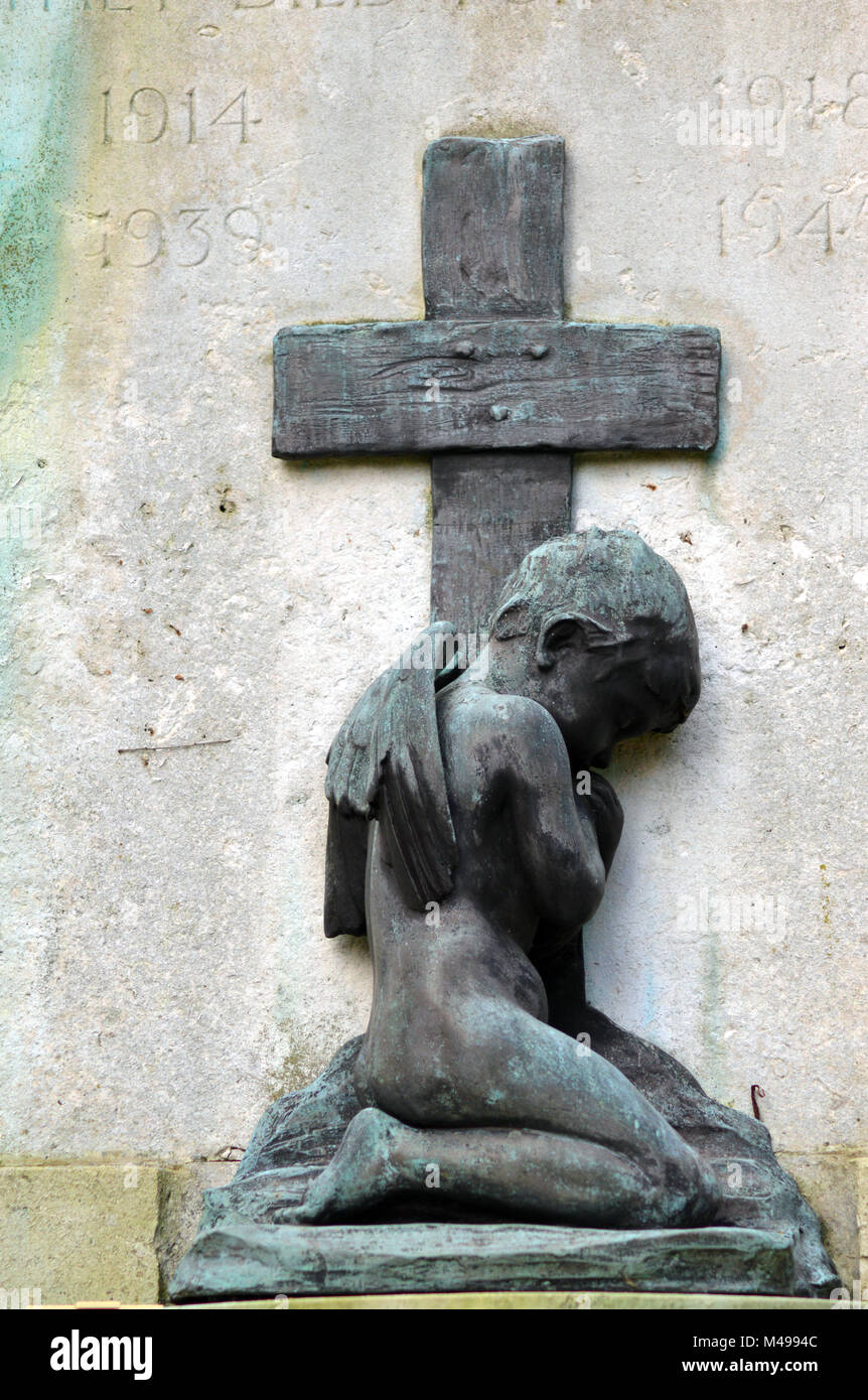 Cherub kneeling in front of the cross Stock Photo