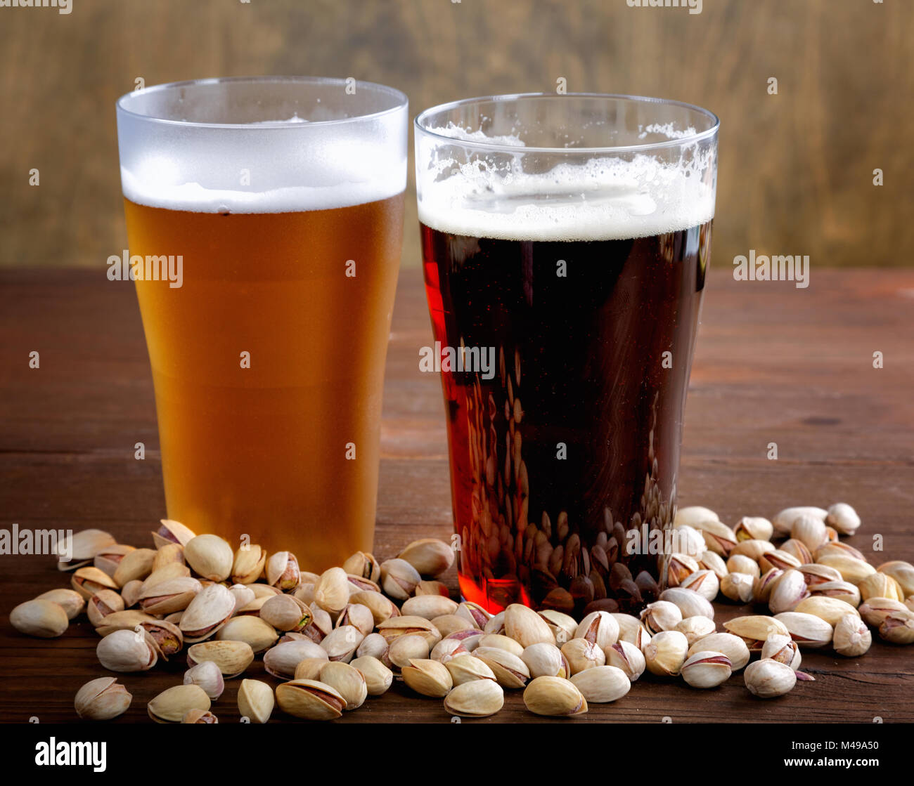 glass of dark and light beer with salty nuts Stock Photo
