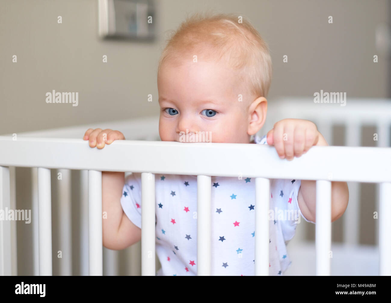 Baby boy standing in crib Stock Photo Alamy