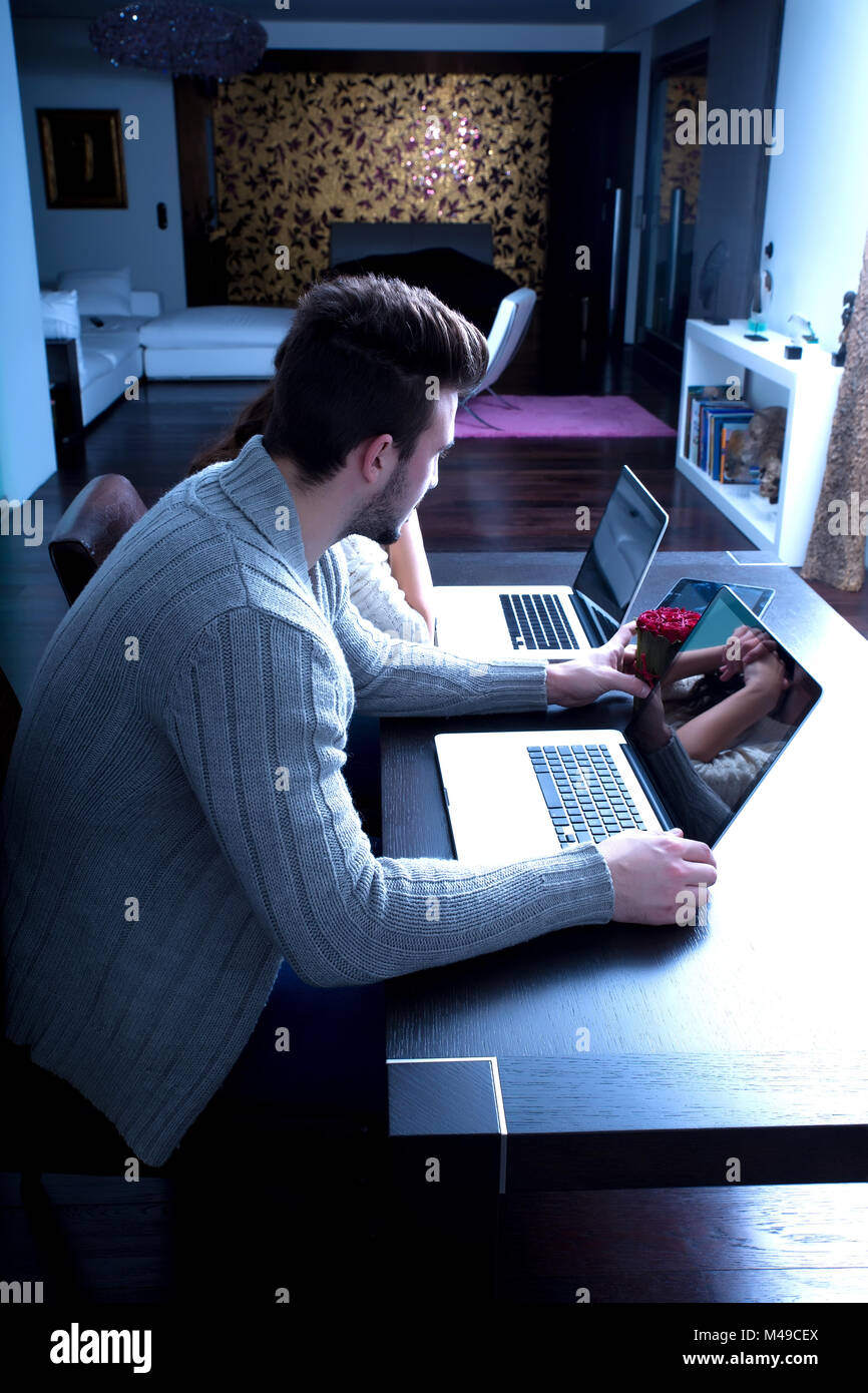 Young couple in front of their Laptop Computers at home Stock Photo - Alamy