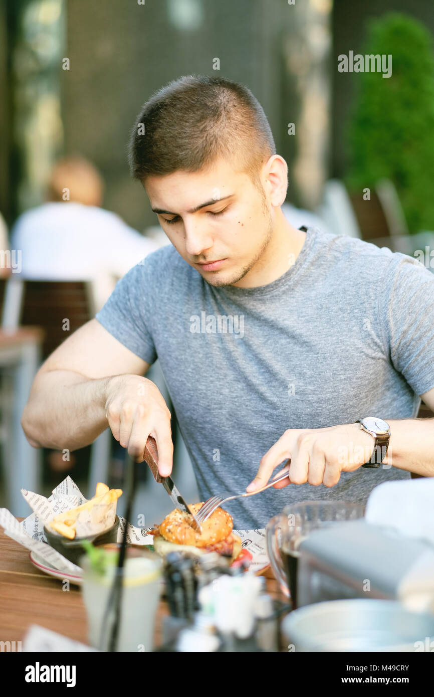 man-having-cheeseburger-in-restaurant-stock-photo-alamy