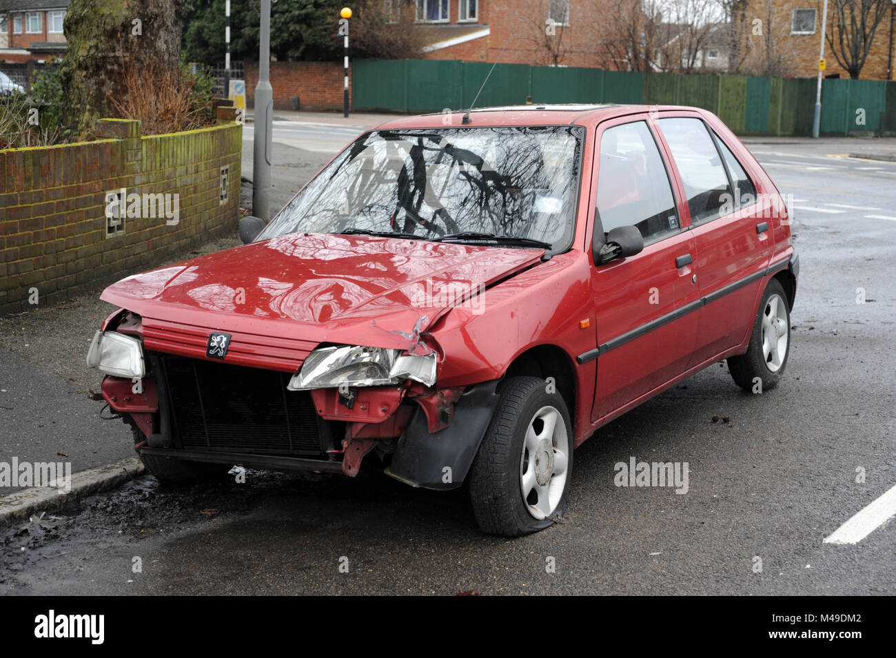 Abandoned damaged red Peugeot on a street in Hayes, Middlesex Stock Photo