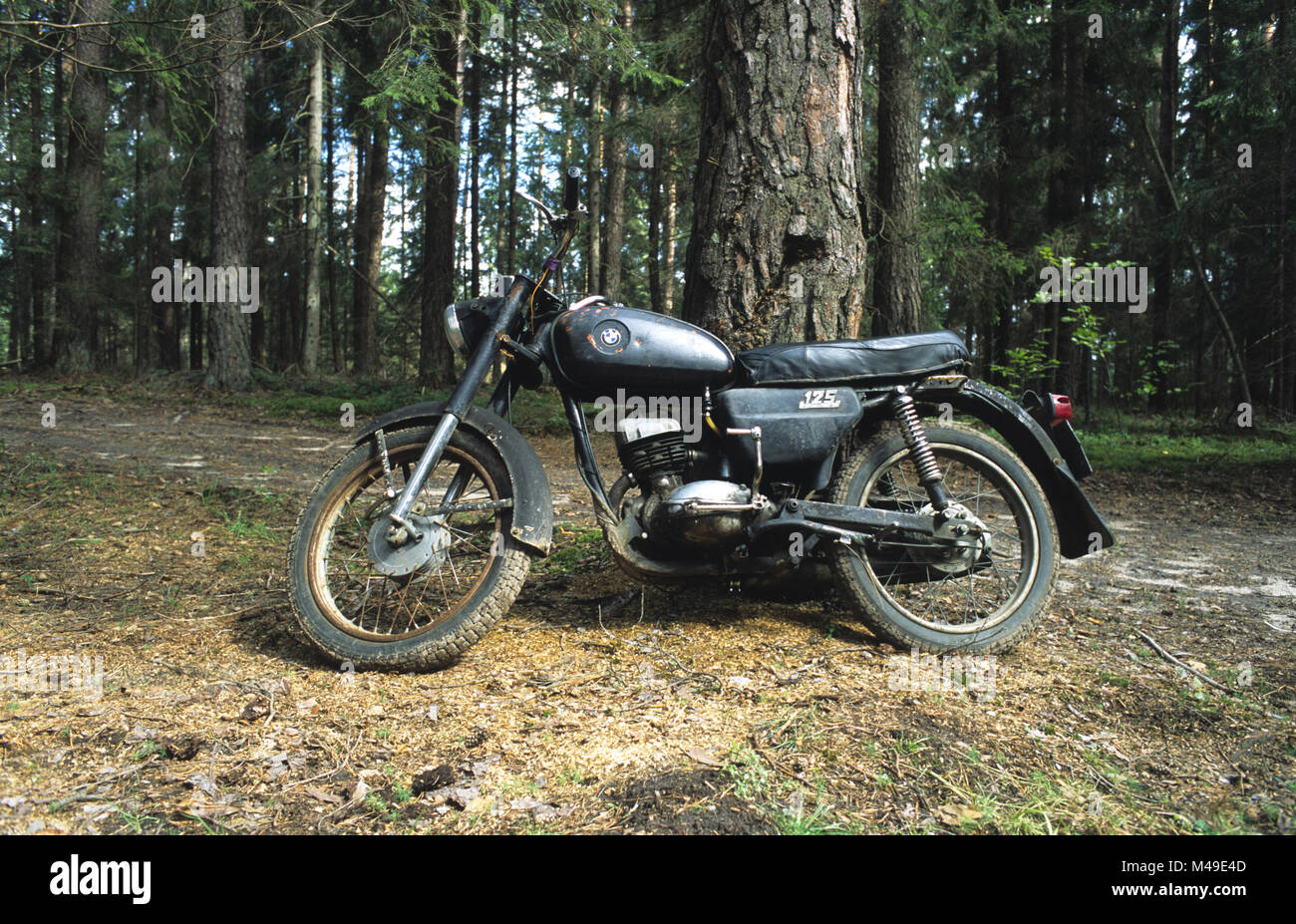 Vintage 125 BMW motorbike in coniferous forest in Suwalszczyzna region of north east Poland August 2007 Stock Photo