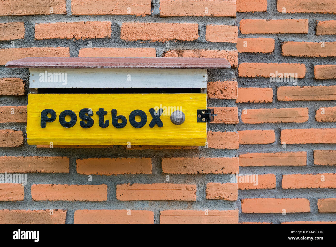 Yellow mailbox on brick home wall background Stock Photo Alamy