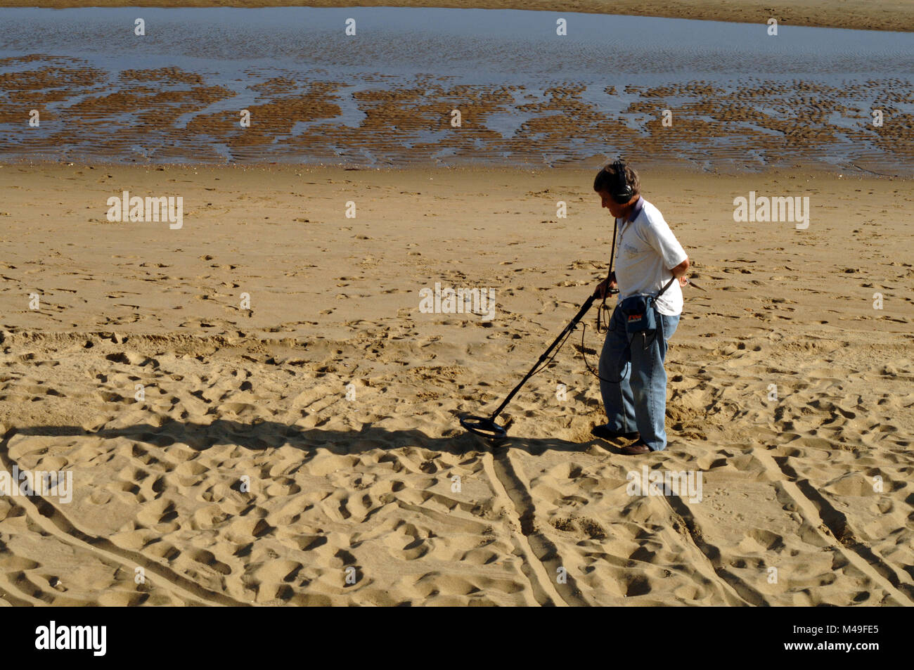 Treasure hunter with metal detector on a beach in the Isle of Wight