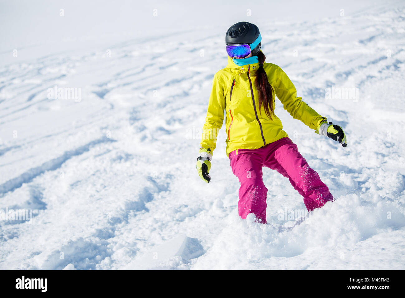 Picture of athlete girl in helmet and mask, snowboarding from snowy