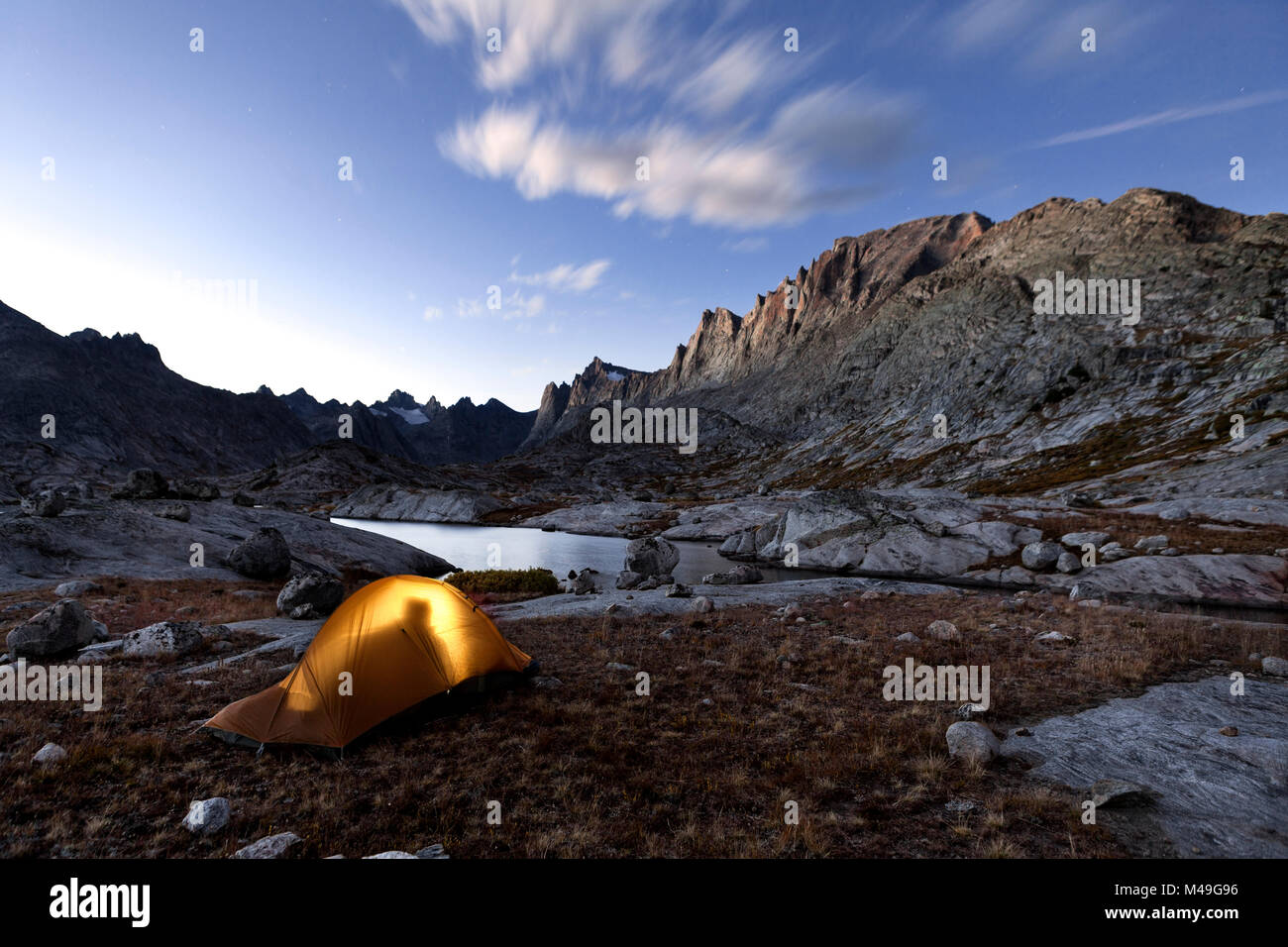 Person silhouetted in tent, camping in Wind River Range, Titcomb Basin, Bridger Wilderness, Bridger National Forest, Wyoming, USA. September 2015. Stock Photo