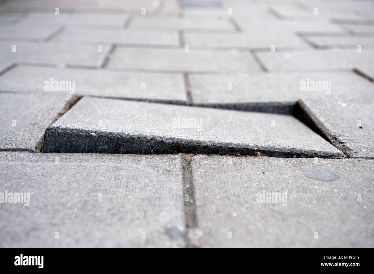 Loose paving slab on a pavement Stock Photo