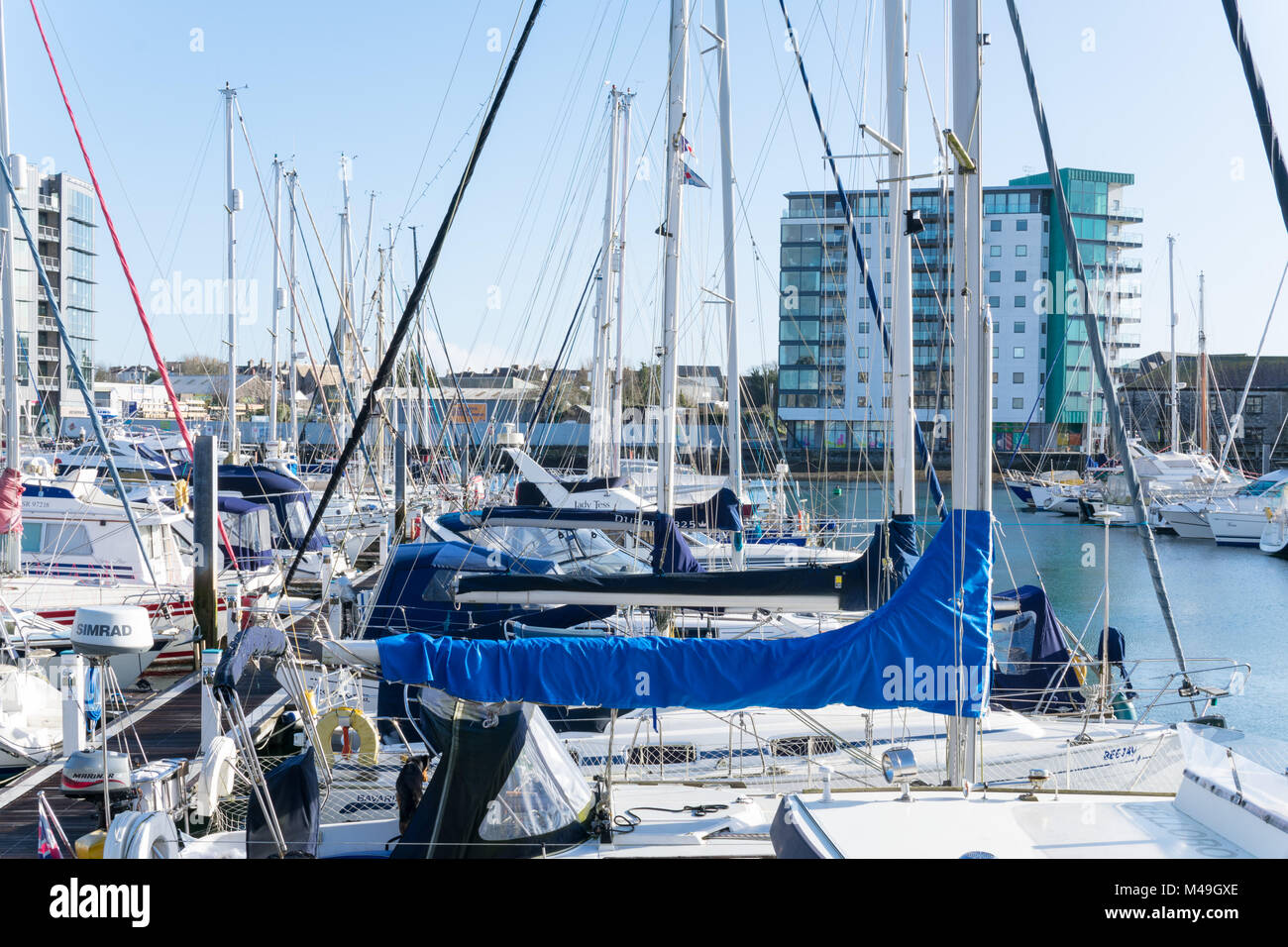 Sutton Harbour Plymouth on a sunny day in February with yachts moored on the pontoons Stock Photo