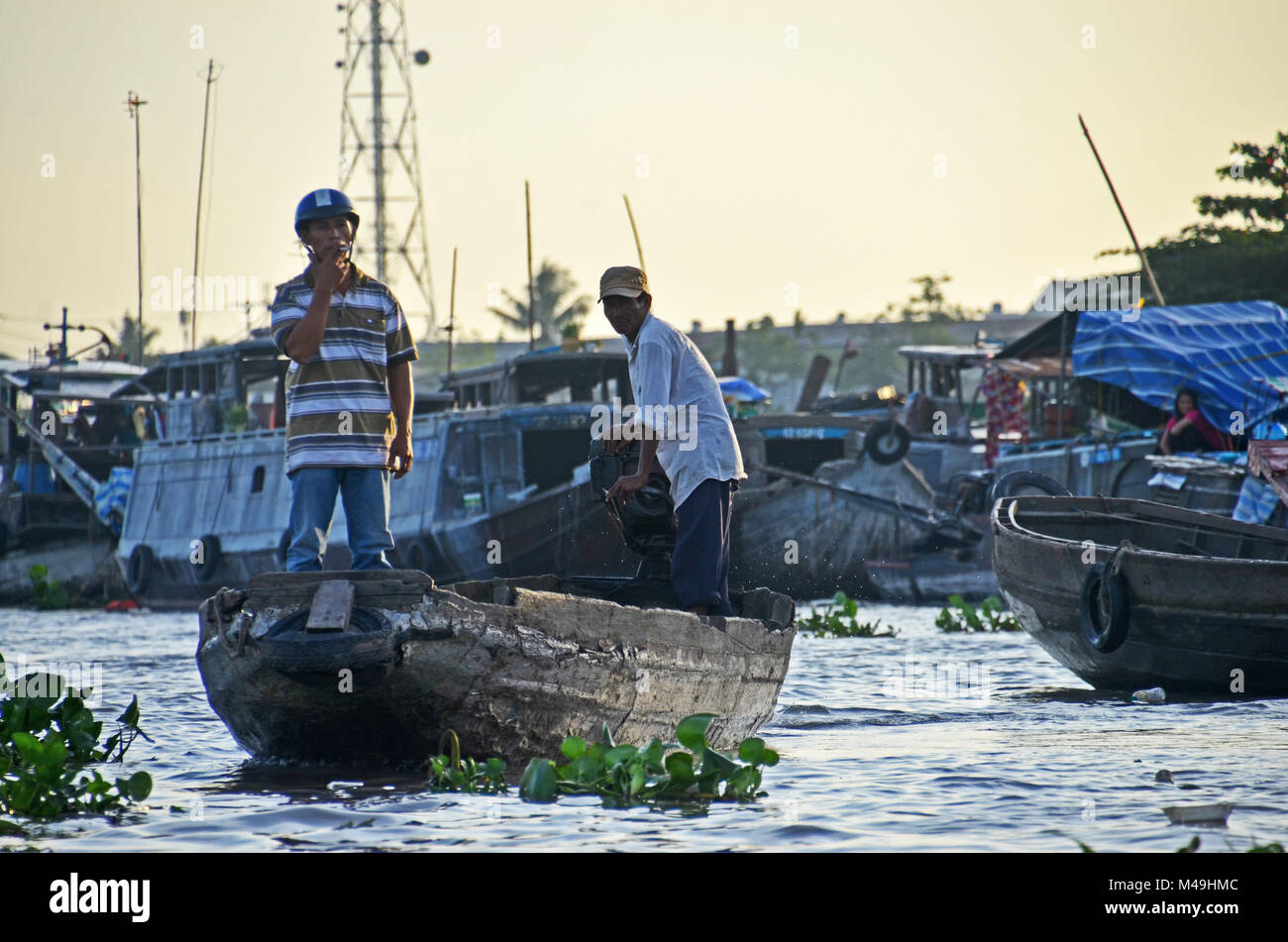 A man smokes a cigarette while standing in the prow of a boat in Cai ...