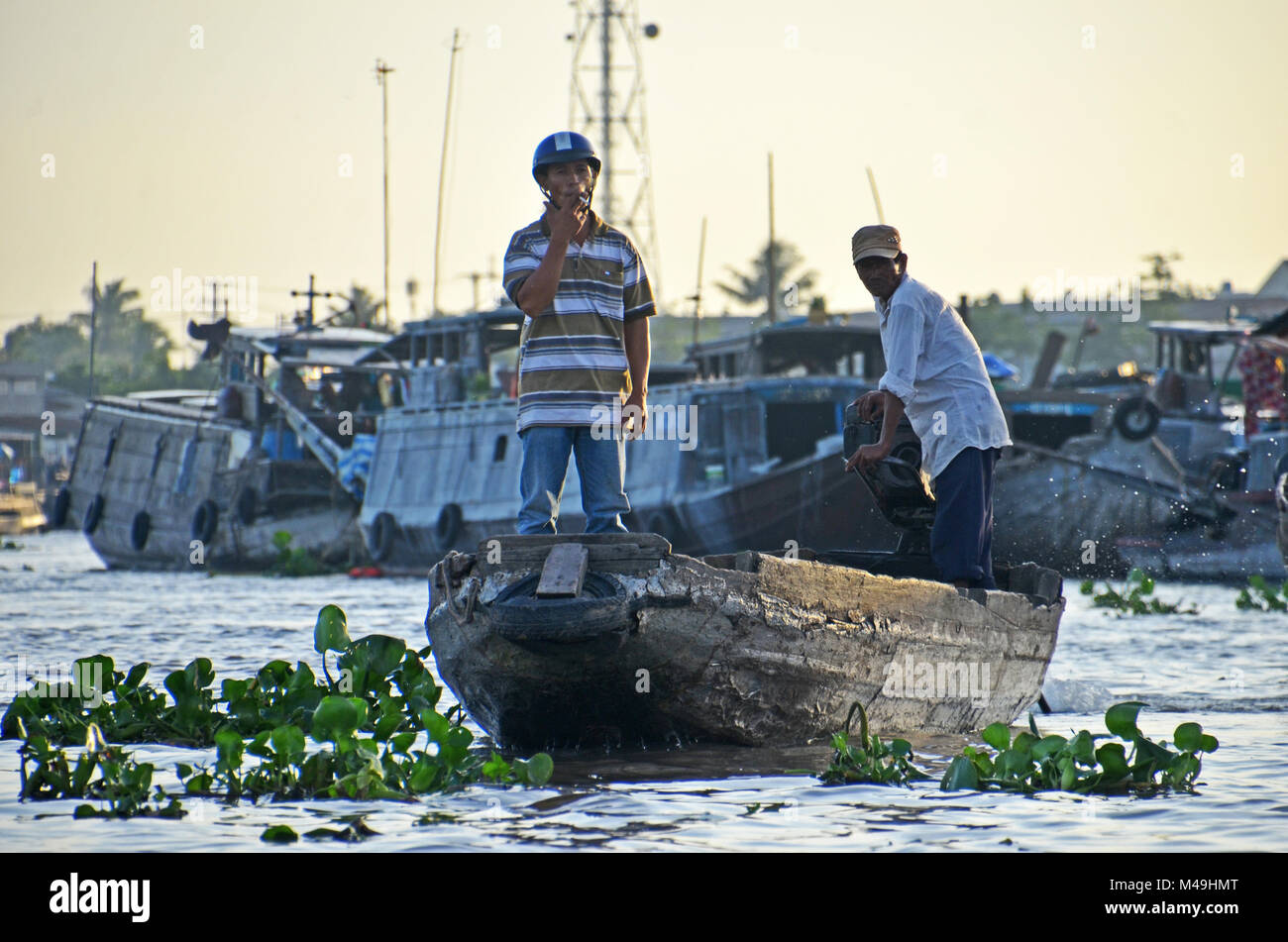 A man smokes a cigarette while standing in the prow of a boat in Cai ...