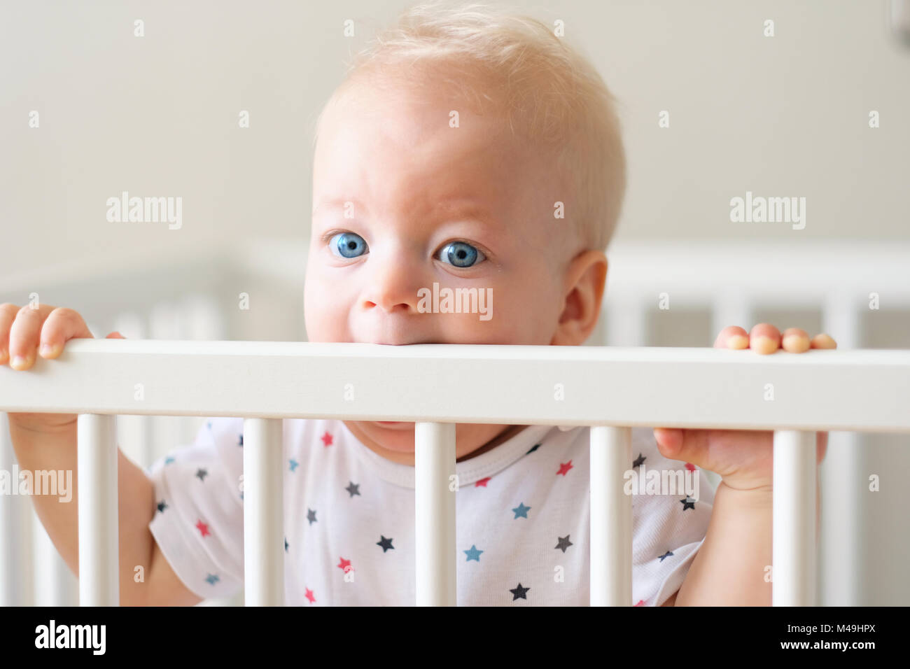 Baby boy standing in crib Stock Photo Alamy