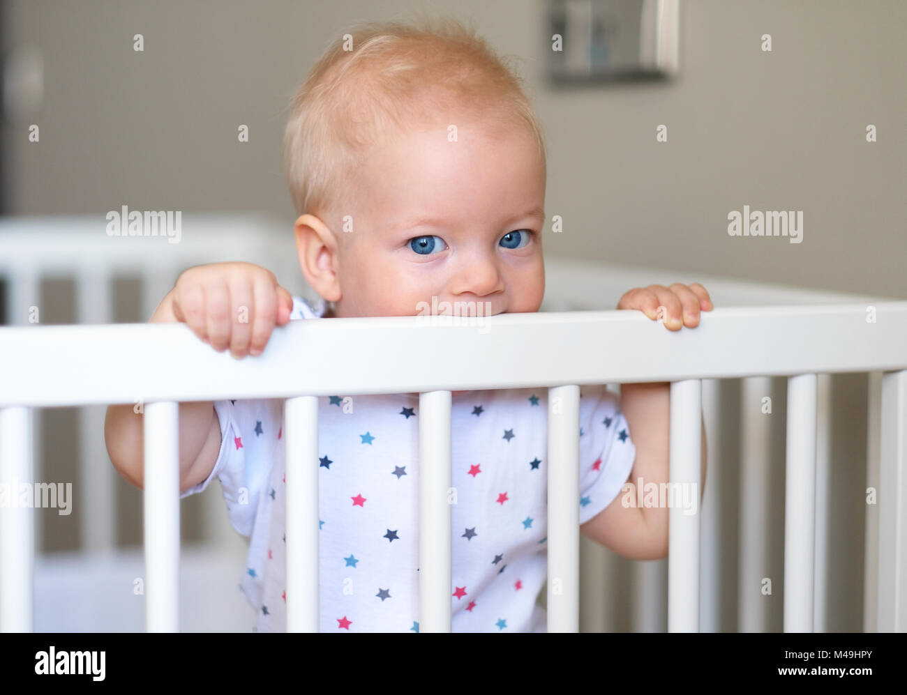 Baby boy standing in crib Stock Photo Alamy
