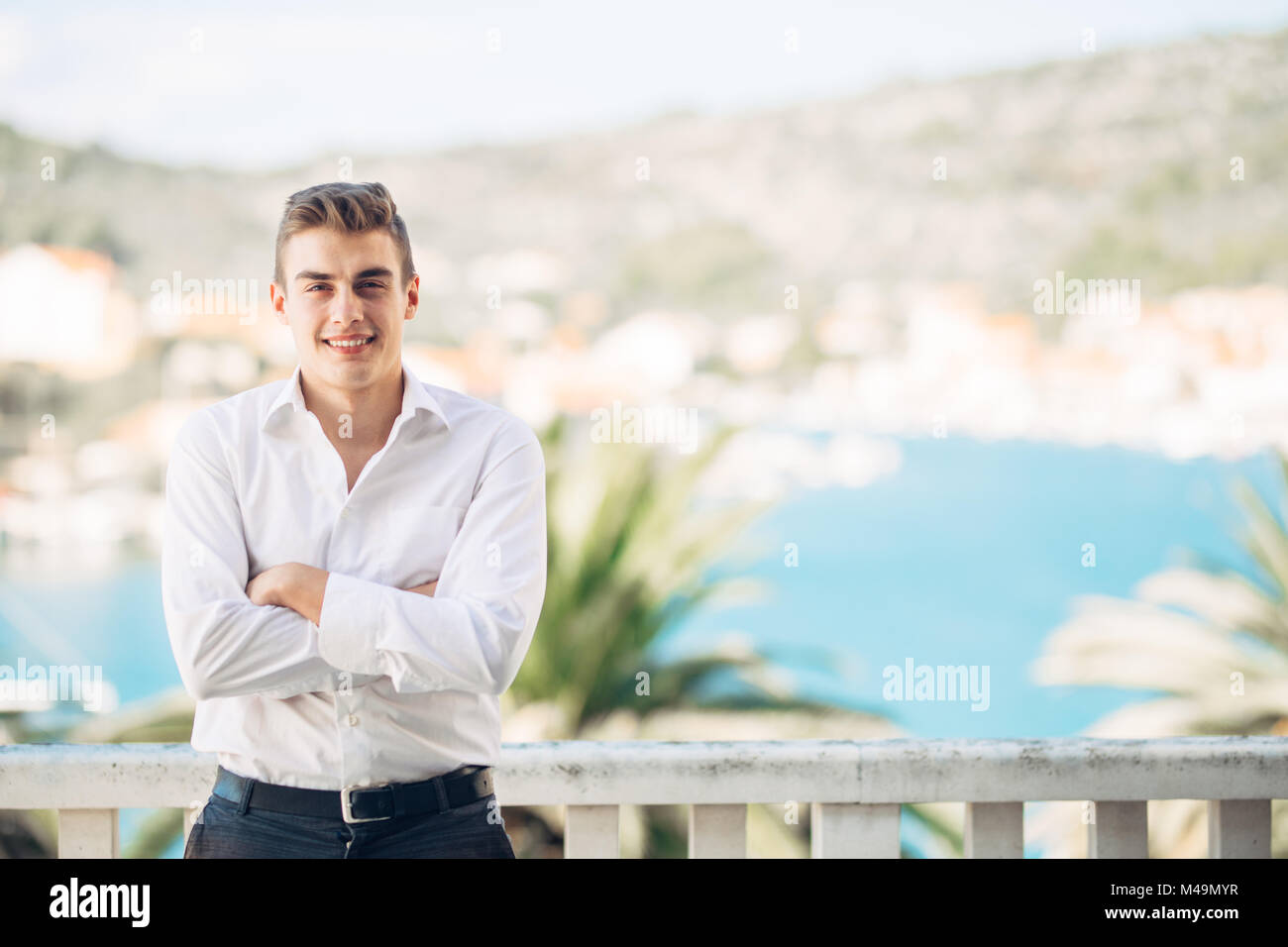 Smiling young person experiencing the reword for hard work,enjoying relaxed summer vacation at the resort.Happiness and sun.Successful man deserved va Stock Photo