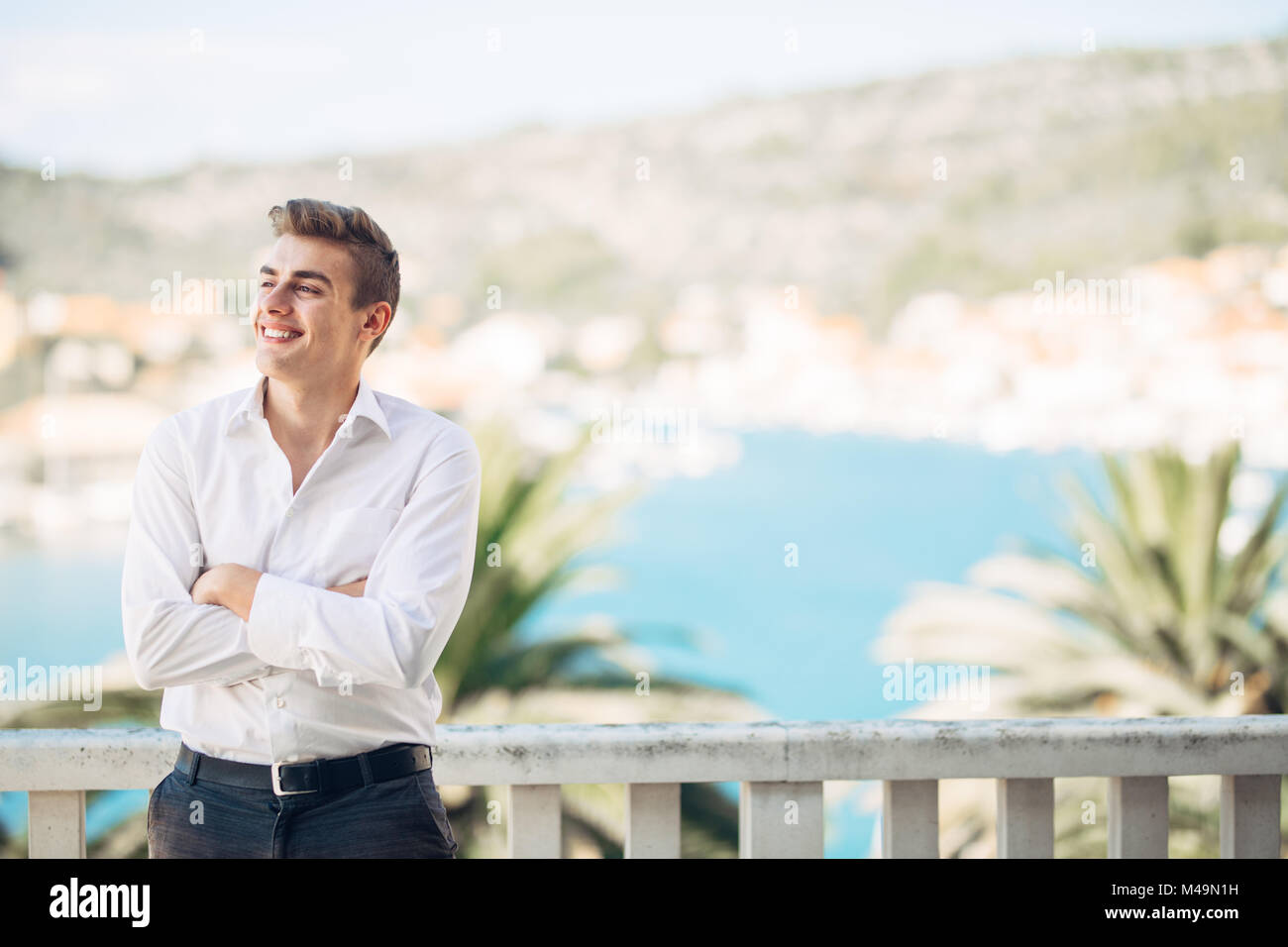 Smiling young person experiencing the reword for hard work,enjoying relaxed summer vacation at the resort.Happiness and sun.Successful man deserved va Stock Photo