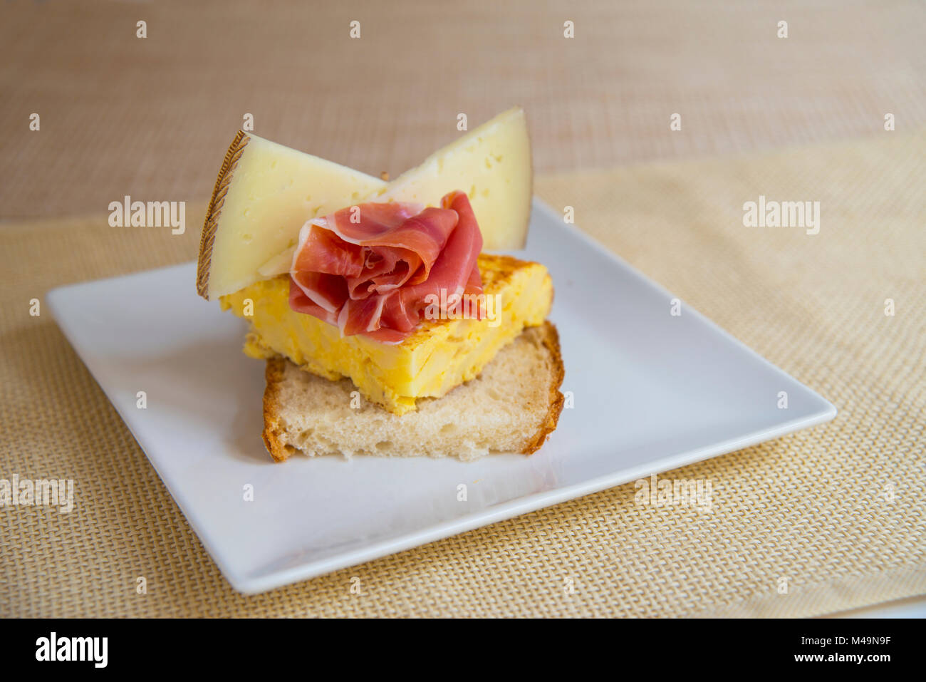 Spanish tapa Manchego cheese, Iberian ham and Spanish omelet on toast