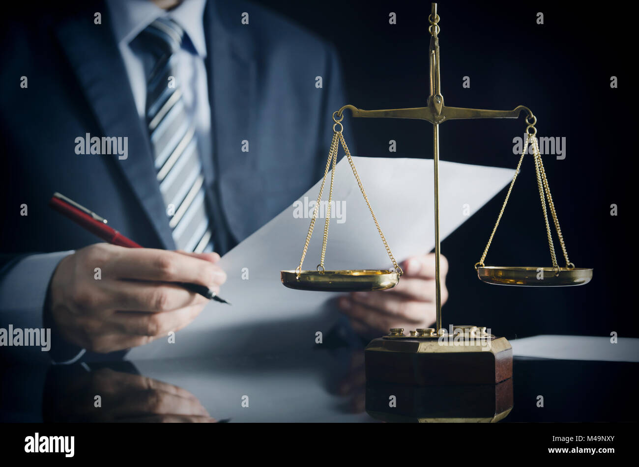 Lawyer or attorney works in his office. Scales on the desk Stock Photo
