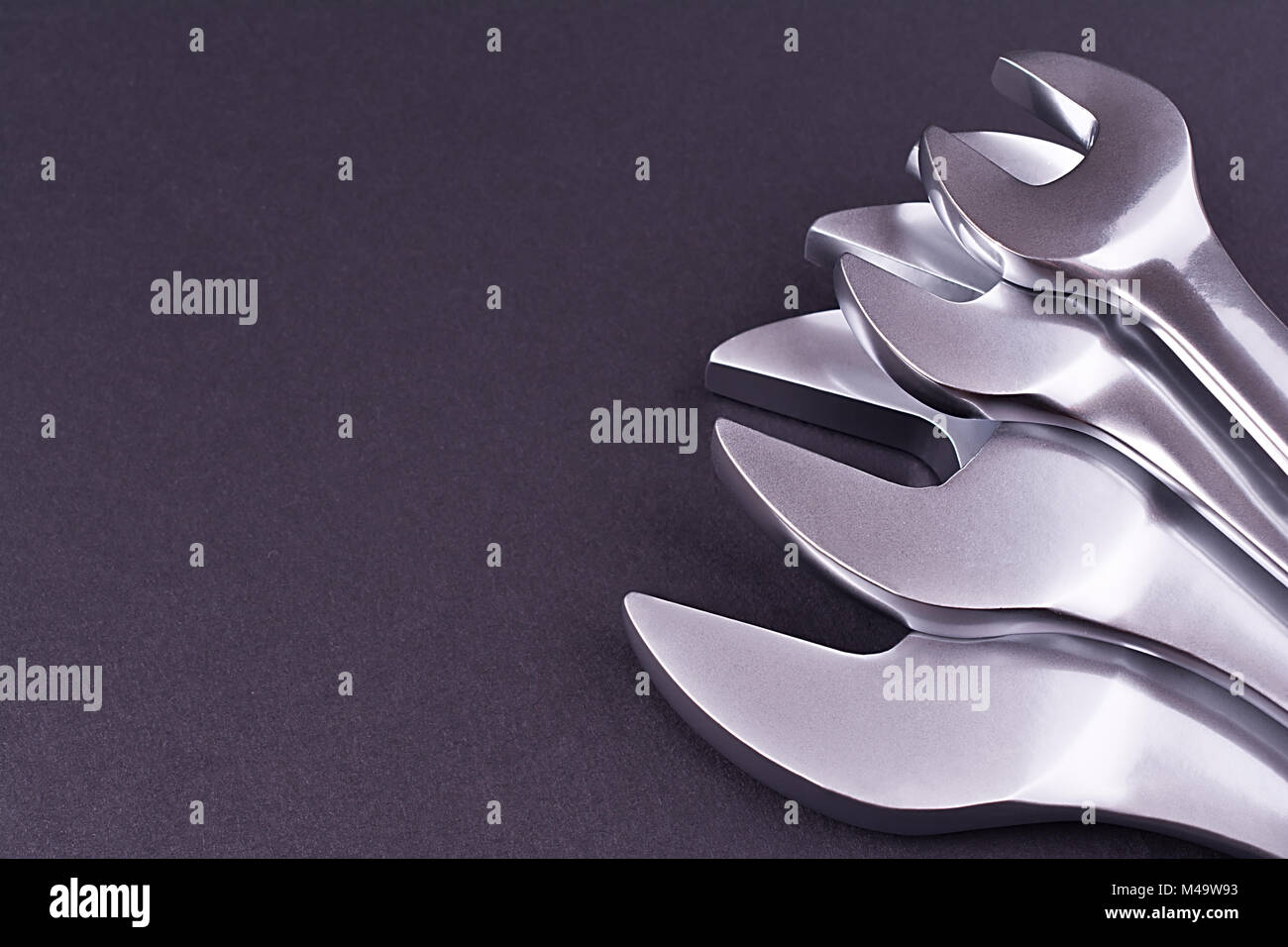 Spanners of various sizes, on dark abstract background Stock Photo - Alamy