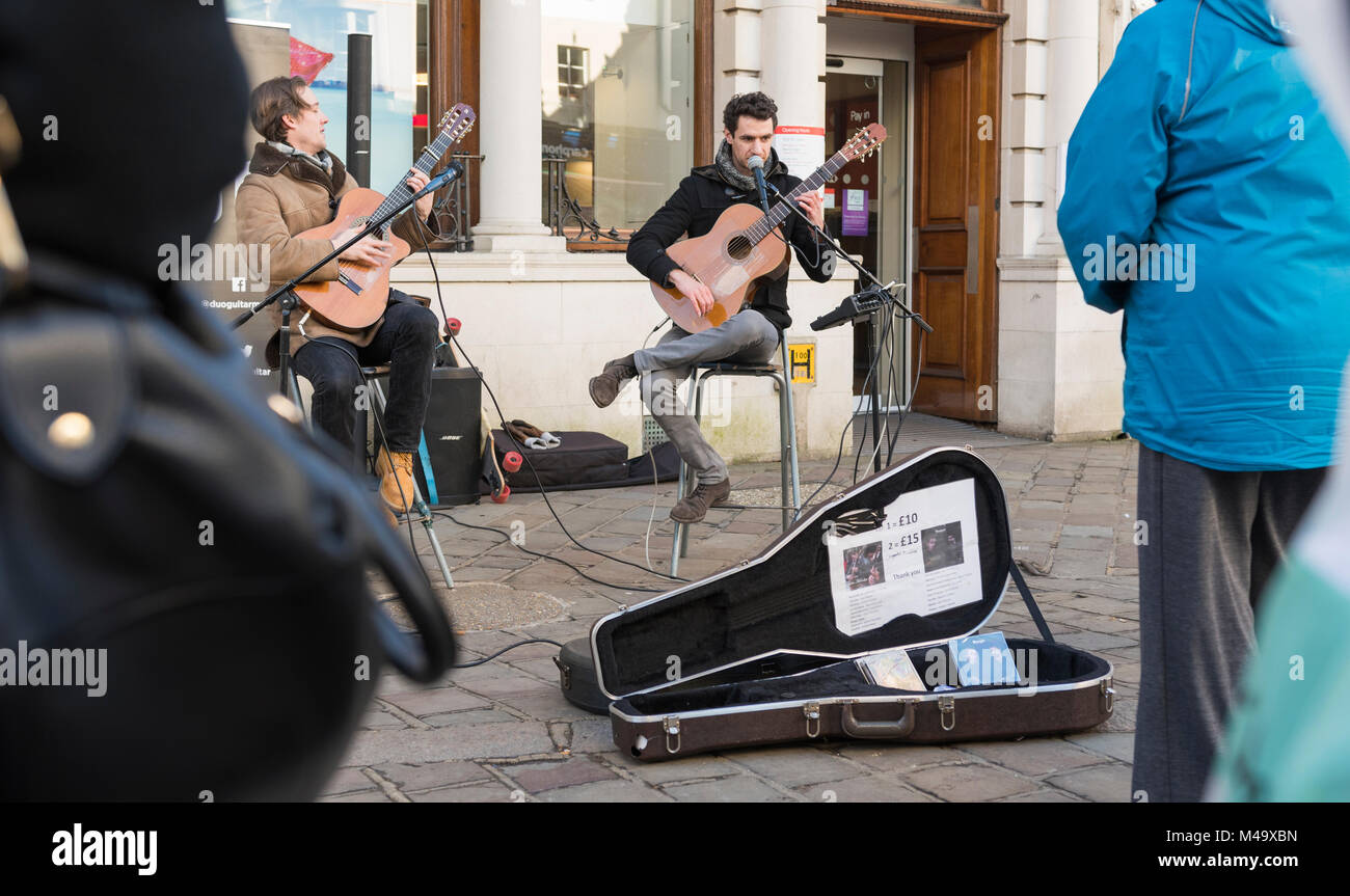Street musicians busking playing guitars in Chichester, West Sussex, England, UK. Stock Photo
