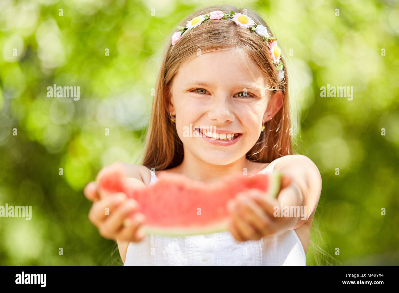 Helpful girl wants to give something of her watermelon Stock Photo