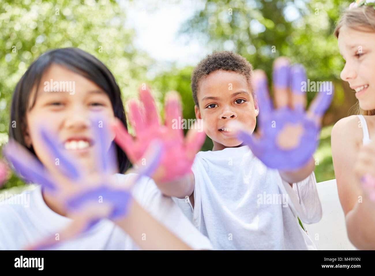 Children in international kindergarten play and paint with finger paints Stock Photo