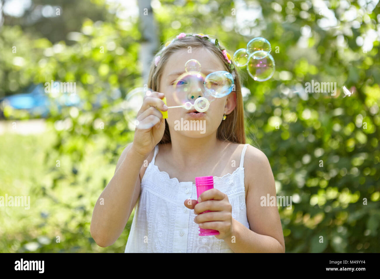 Girl blows soap bubbles in the summer as a sign of transience Stock Photo