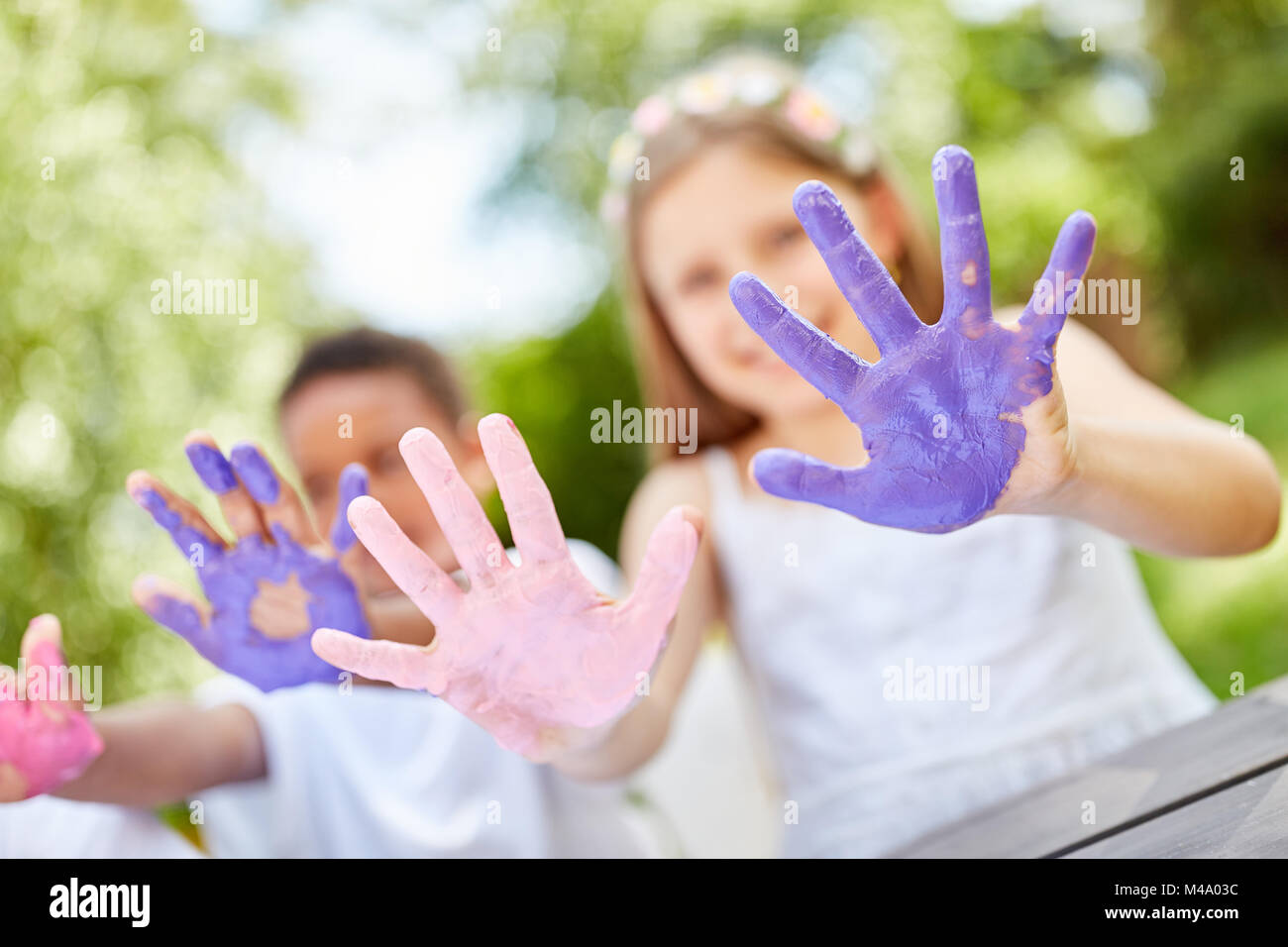 Children show their smeared hands while painting with finger paints Stock Photo