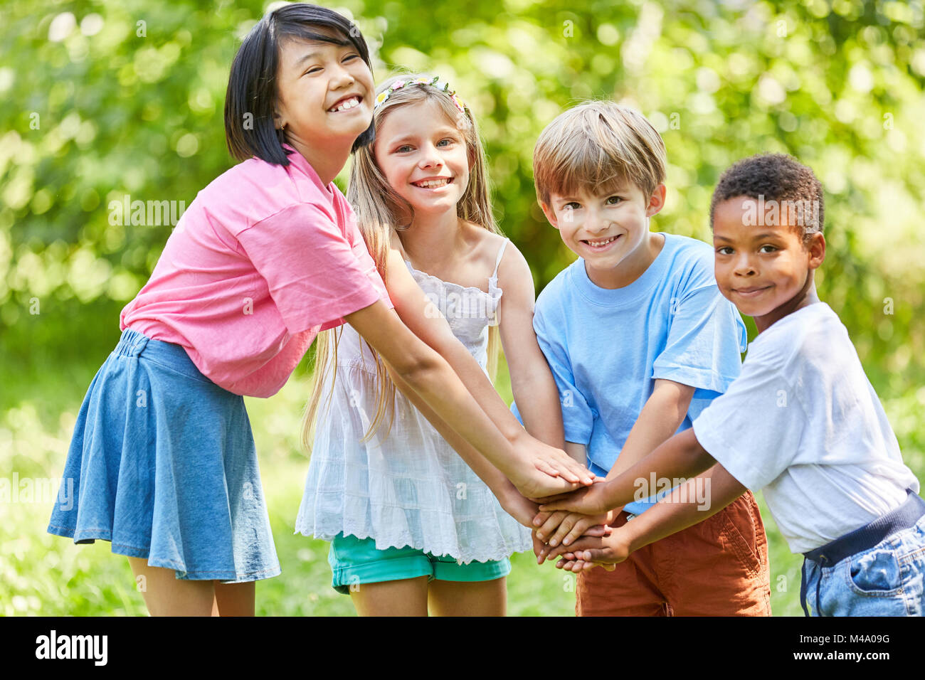 Children in the international kindergarten stack hands for integration Stock Photo