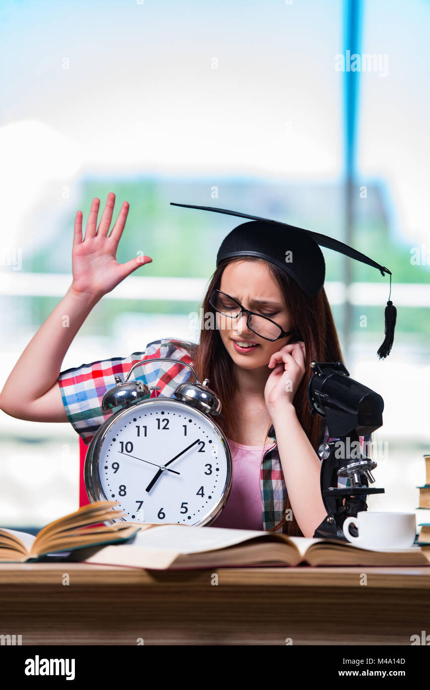 Young girl preparing for exams with large clock Stock Photo Alamy
